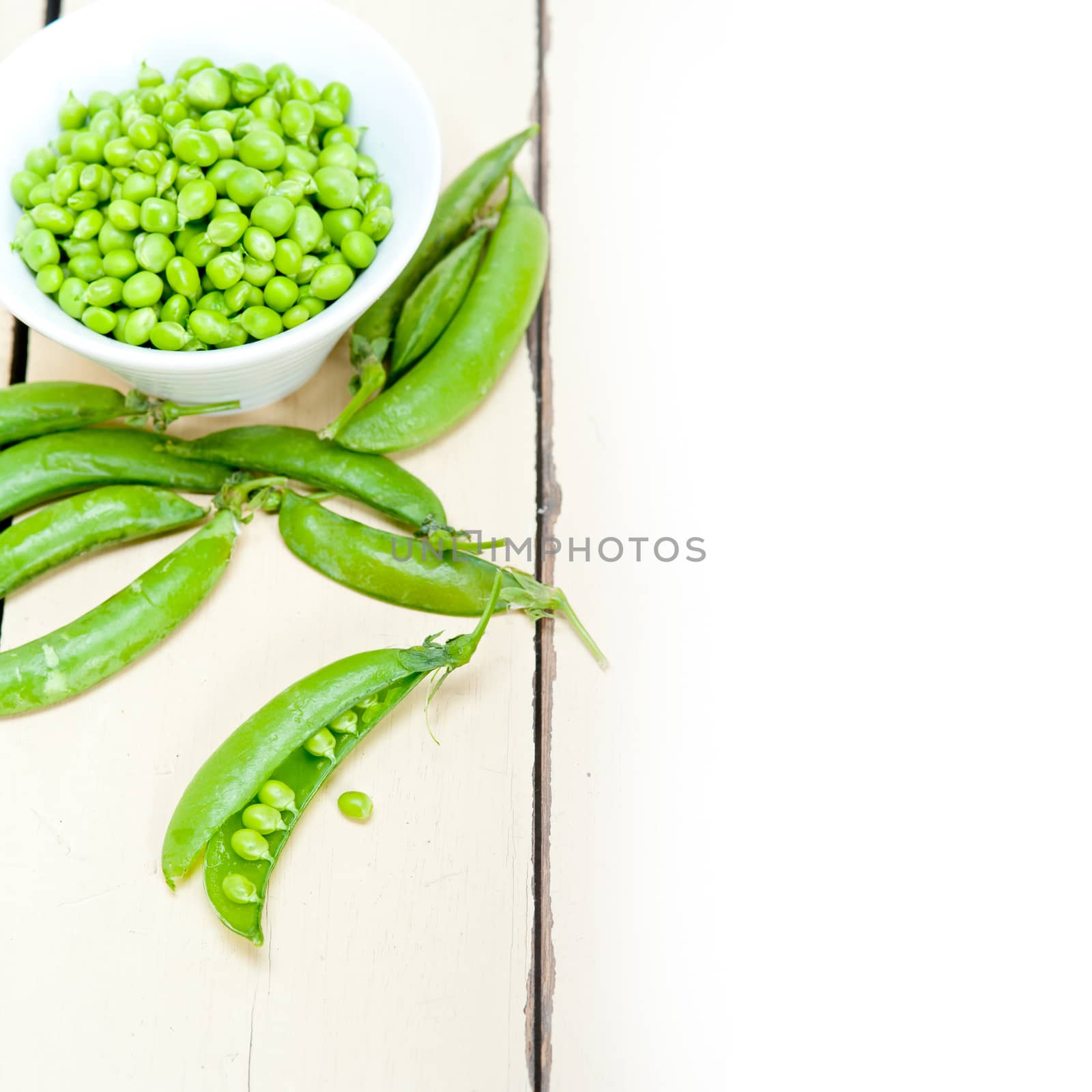 hearthy fresh green peas  over a rustic wood table