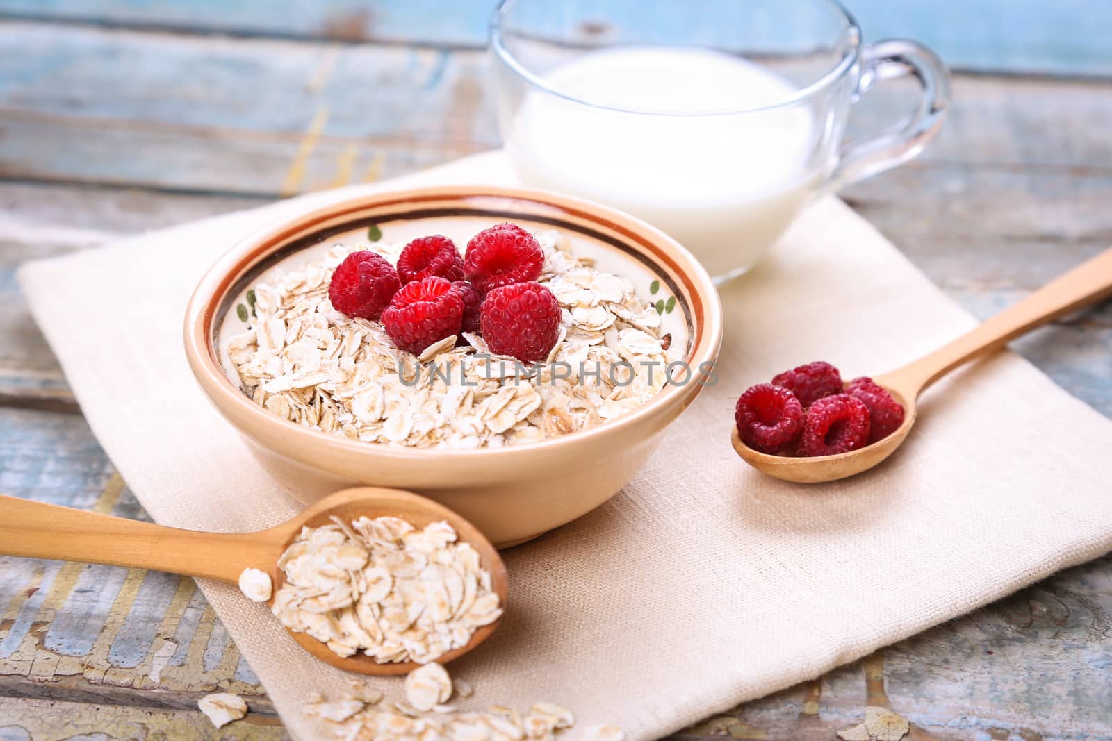oat flakes with raspberry in a bowl on textile