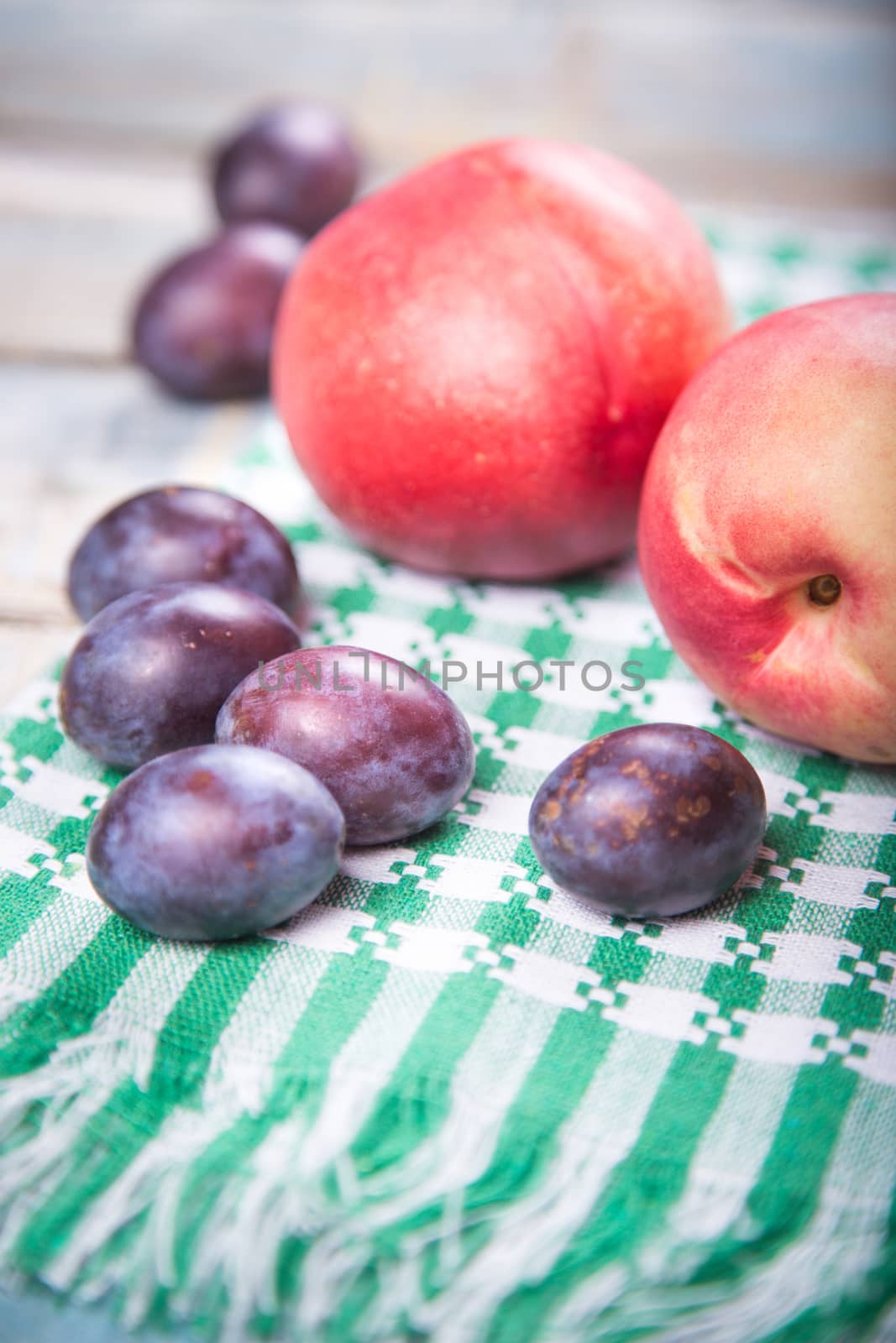 fresh raw ripe nectarin and plums on green textile