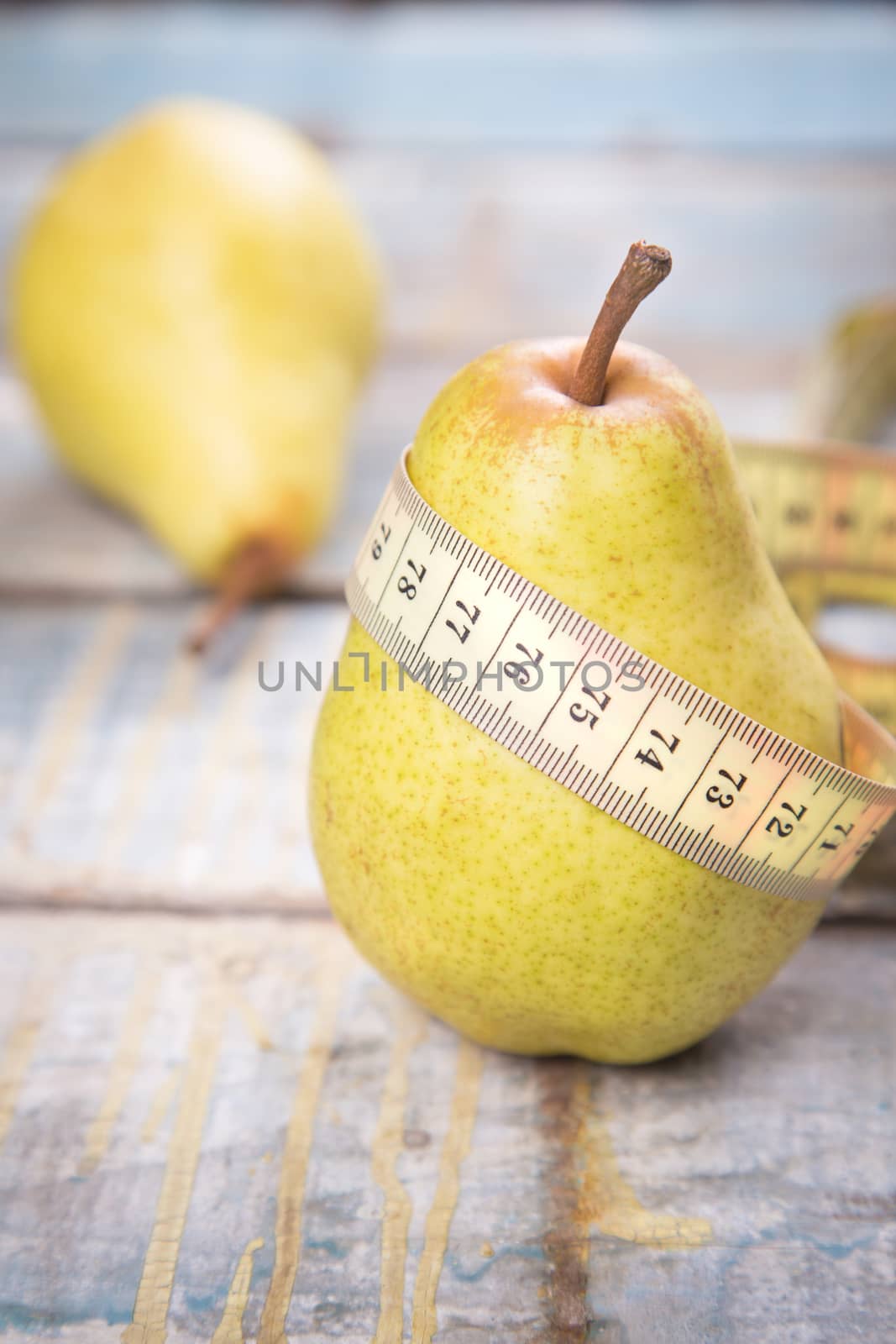 two raw ripe pears on wooden background in studio