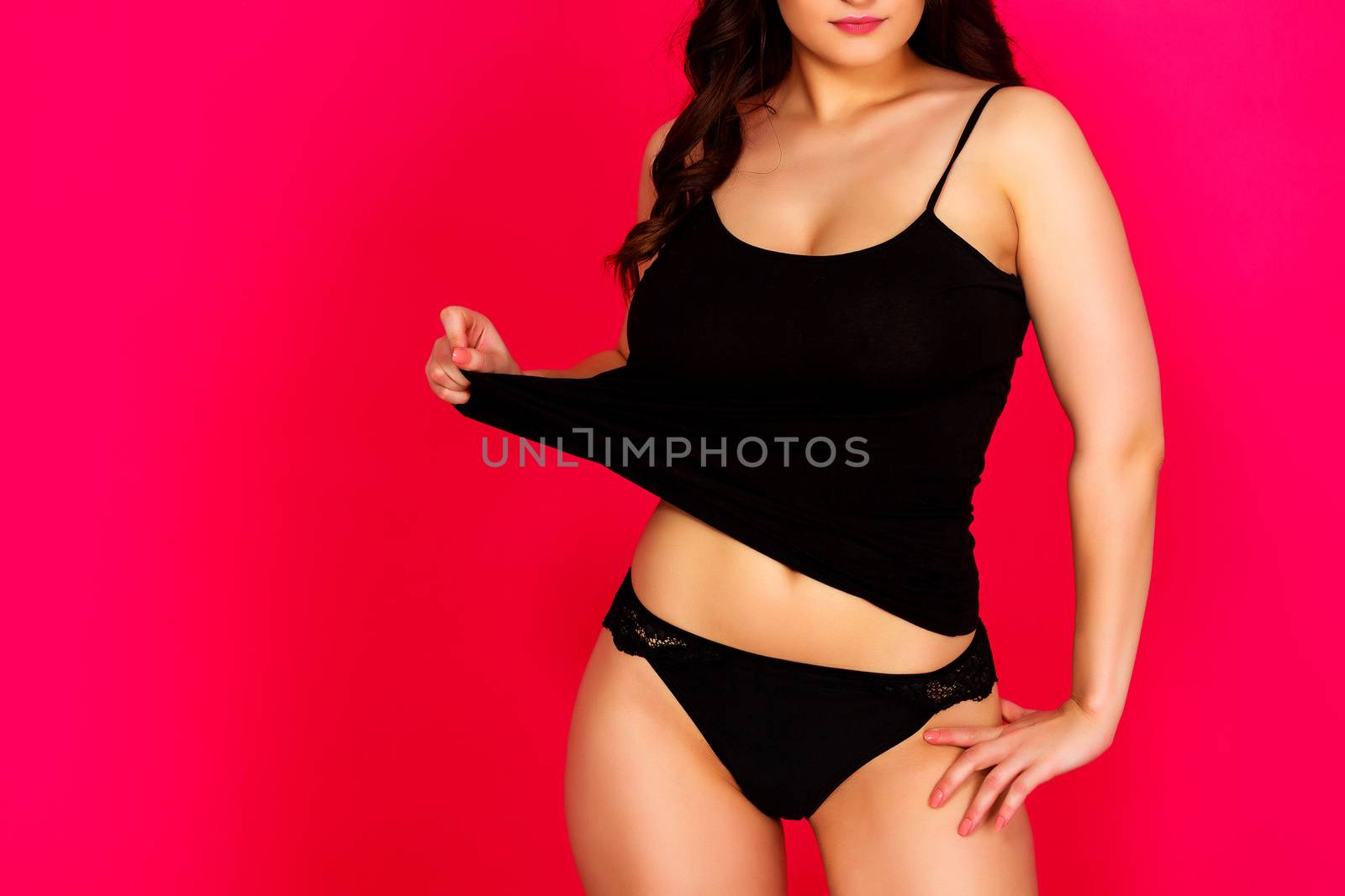 Woman with sexy body posing against a red background