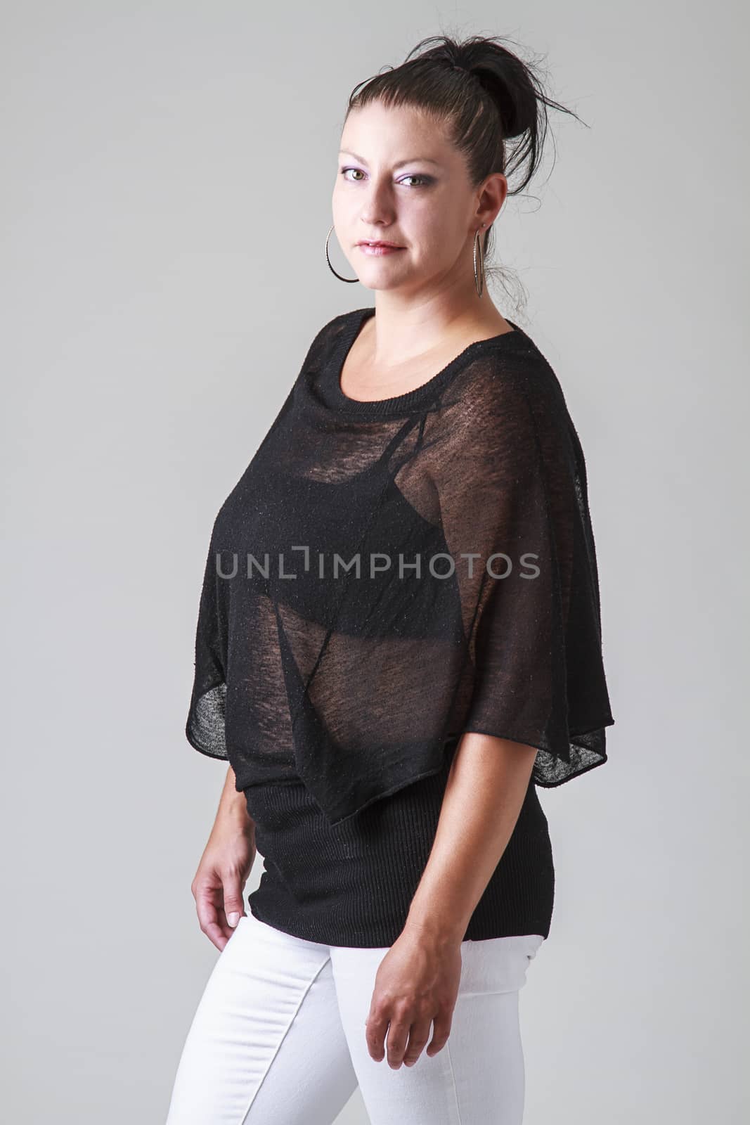 mid-30 woman with transparent shirt and white pants