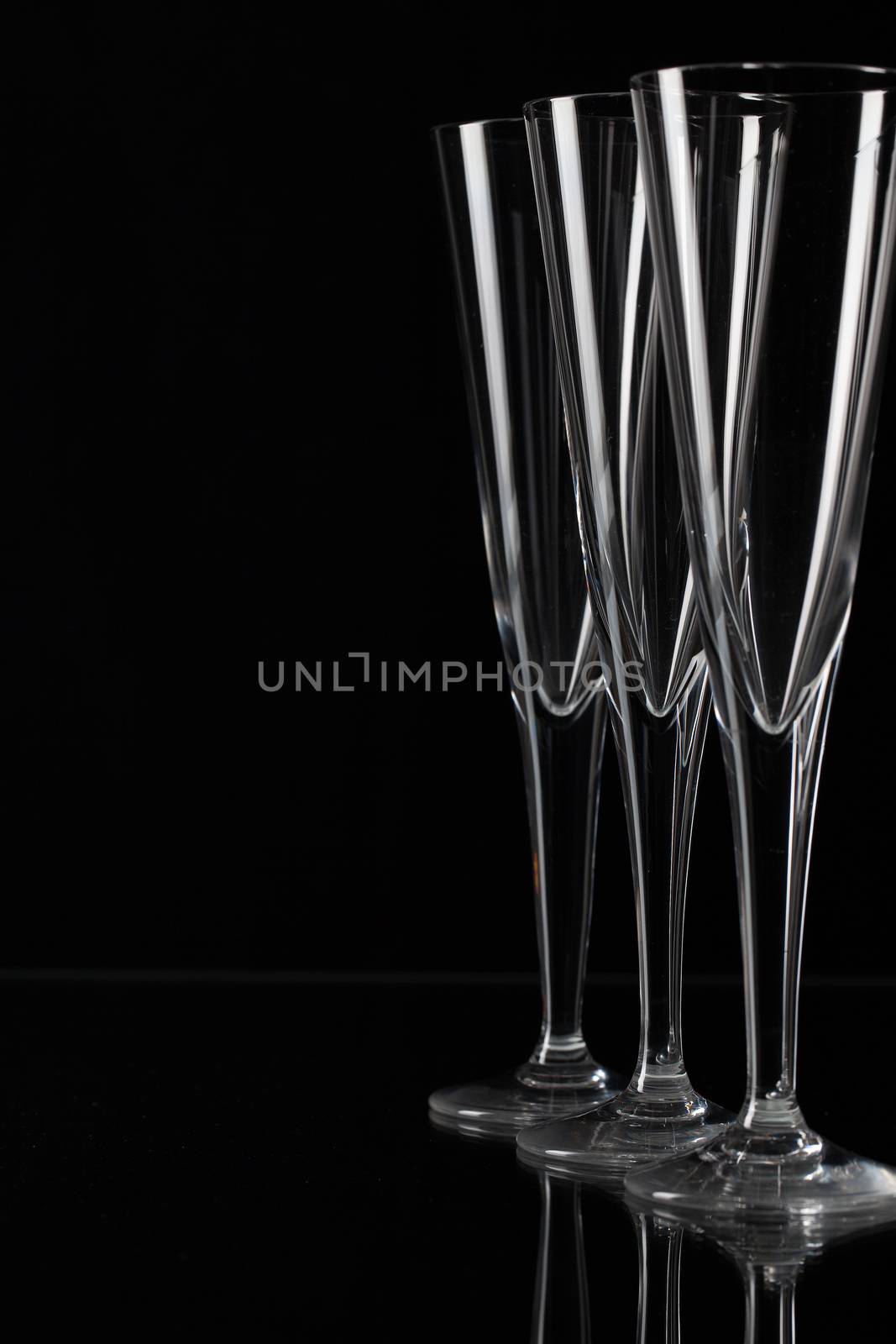 Three empty champagne glasses on a glass plate