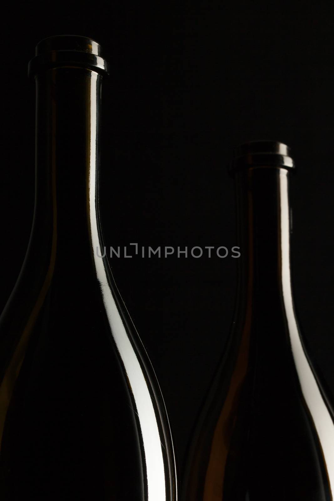 Silhouettes of elegant wine bottles on a black background