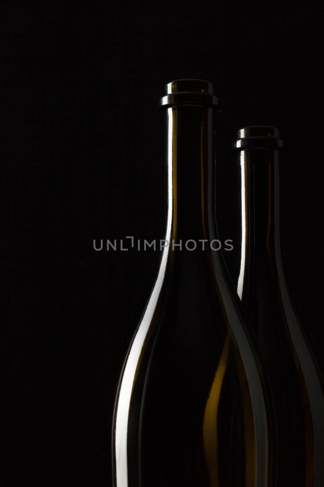 Silhouettes of elegant wine bottles on a black background