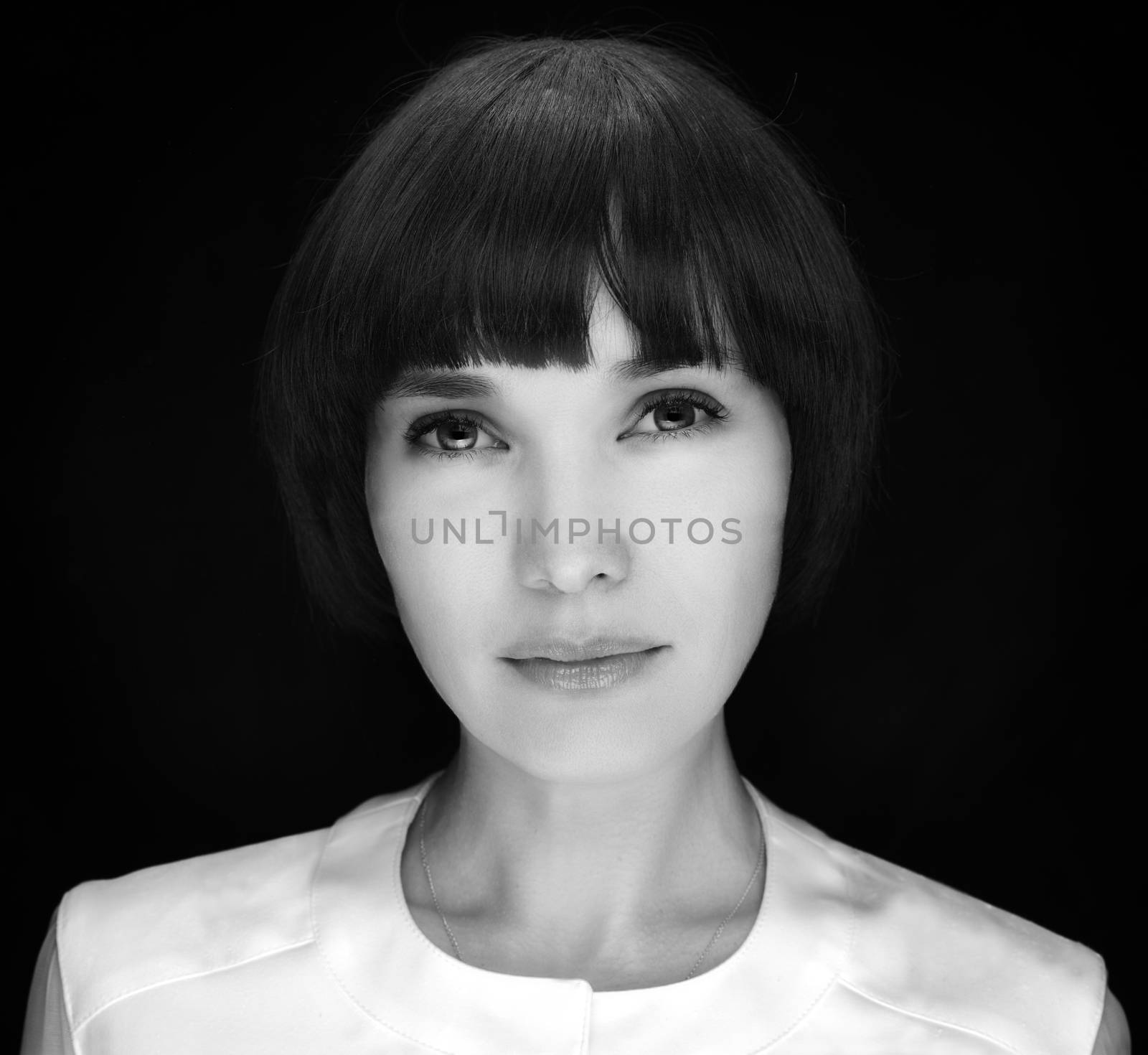 Black and white portrait of pretty young woman on black background