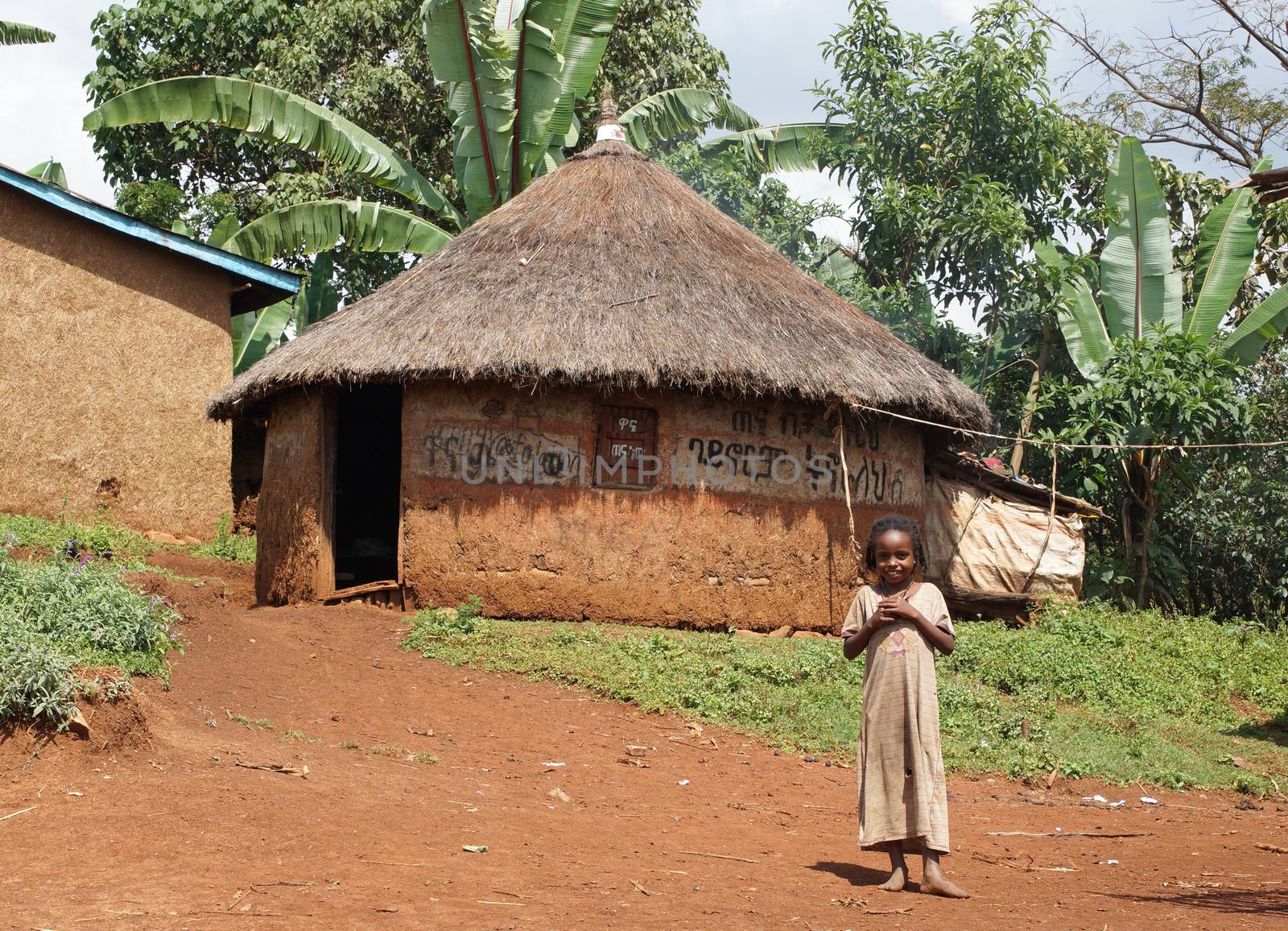 YIRGALEM, ETHIOPIA - NOVEMBER 22, 2014: Young girl in front of a typical house of Sidama people on November 22, 2014 in Yirgalem, Ethiopia.