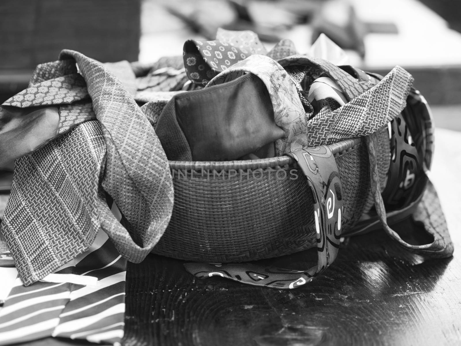 Black and white image of straw basket with neckties