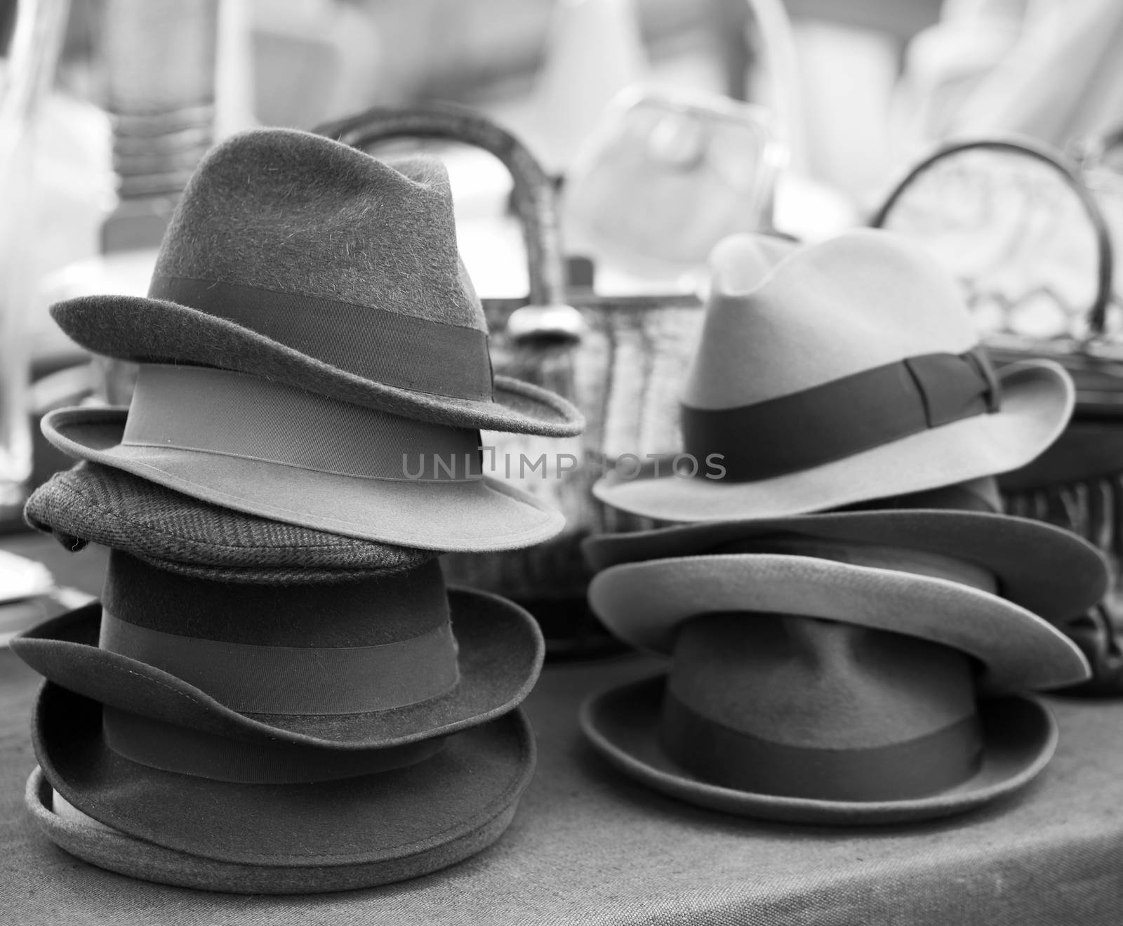 Black and white image of old vintage hats on street market