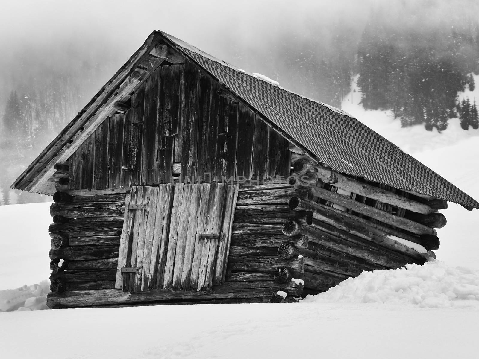 Closeup Black and White image of wooden barn in snowy mountains