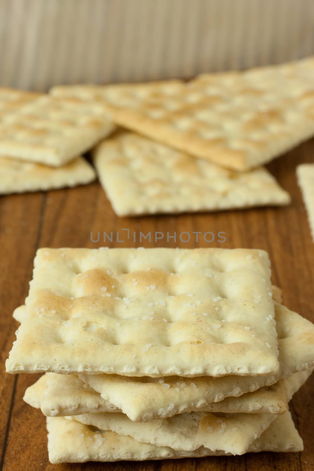 Saltine Crackers on a wooden table top or counter.