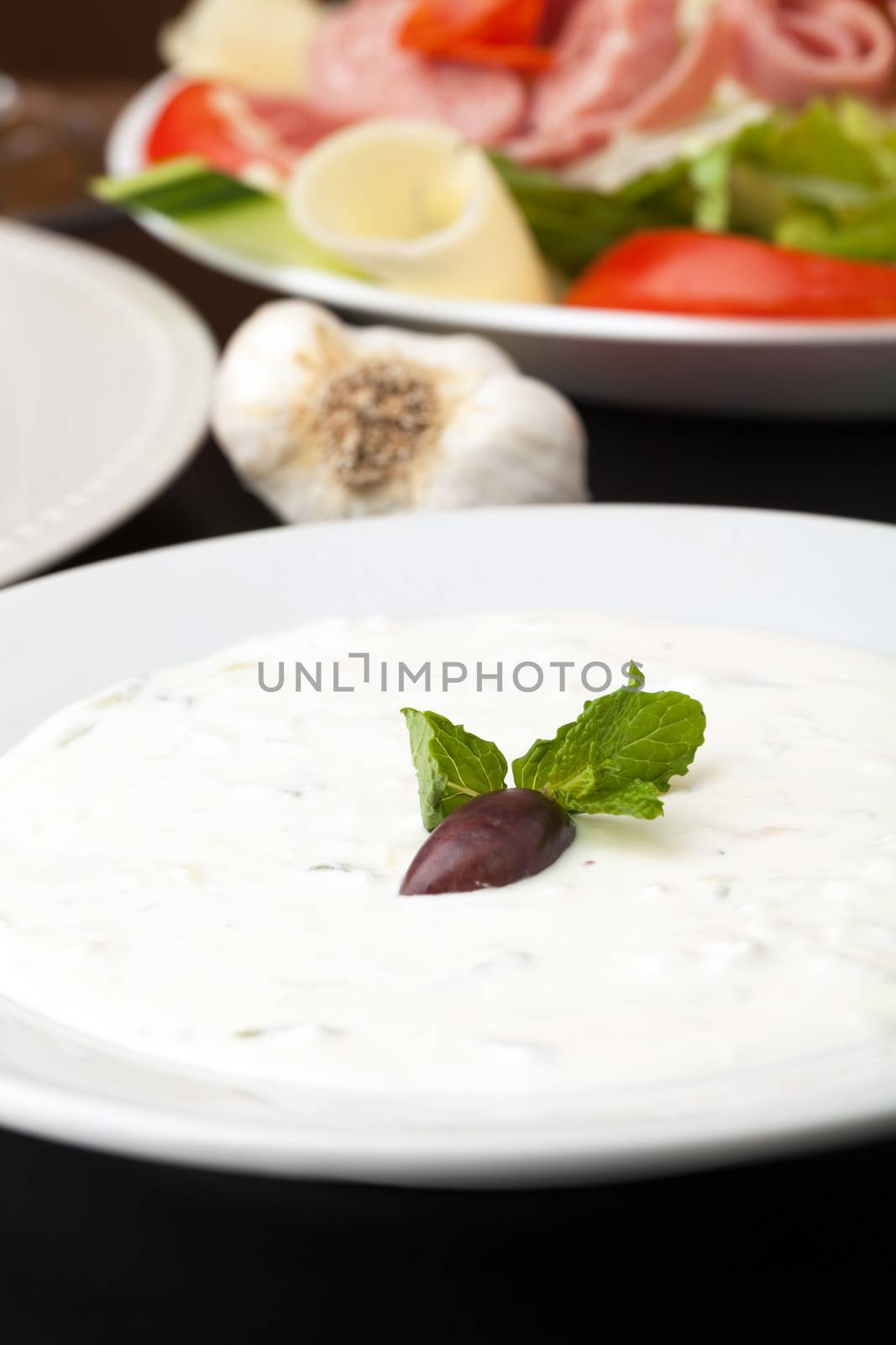 Traditional Gyro sandwich tzatziki sauce garnished with a kalamata olive and mint. Shallow depth of field.