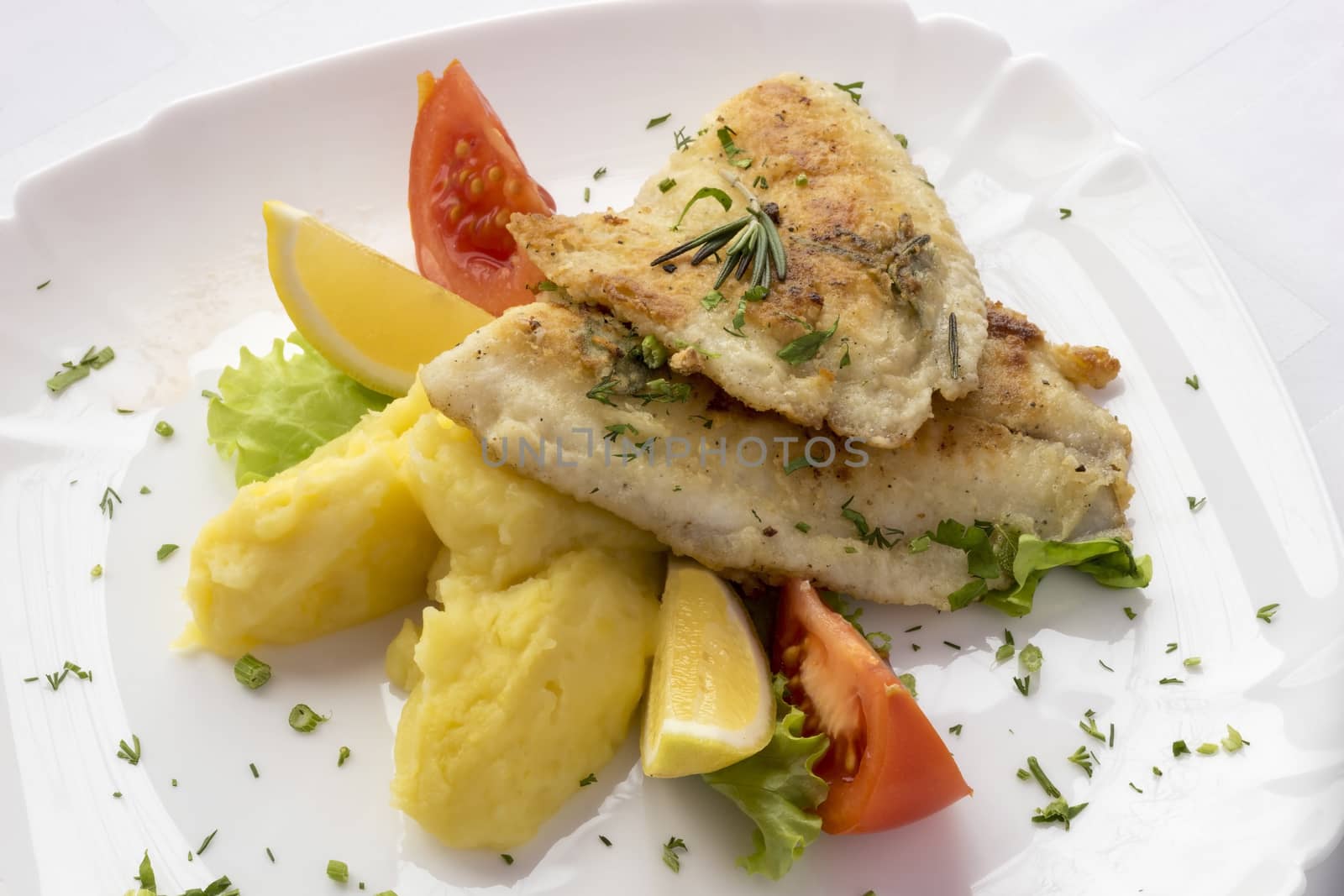 Tilapia fillet with lemon ,tomatoes and potatoes.