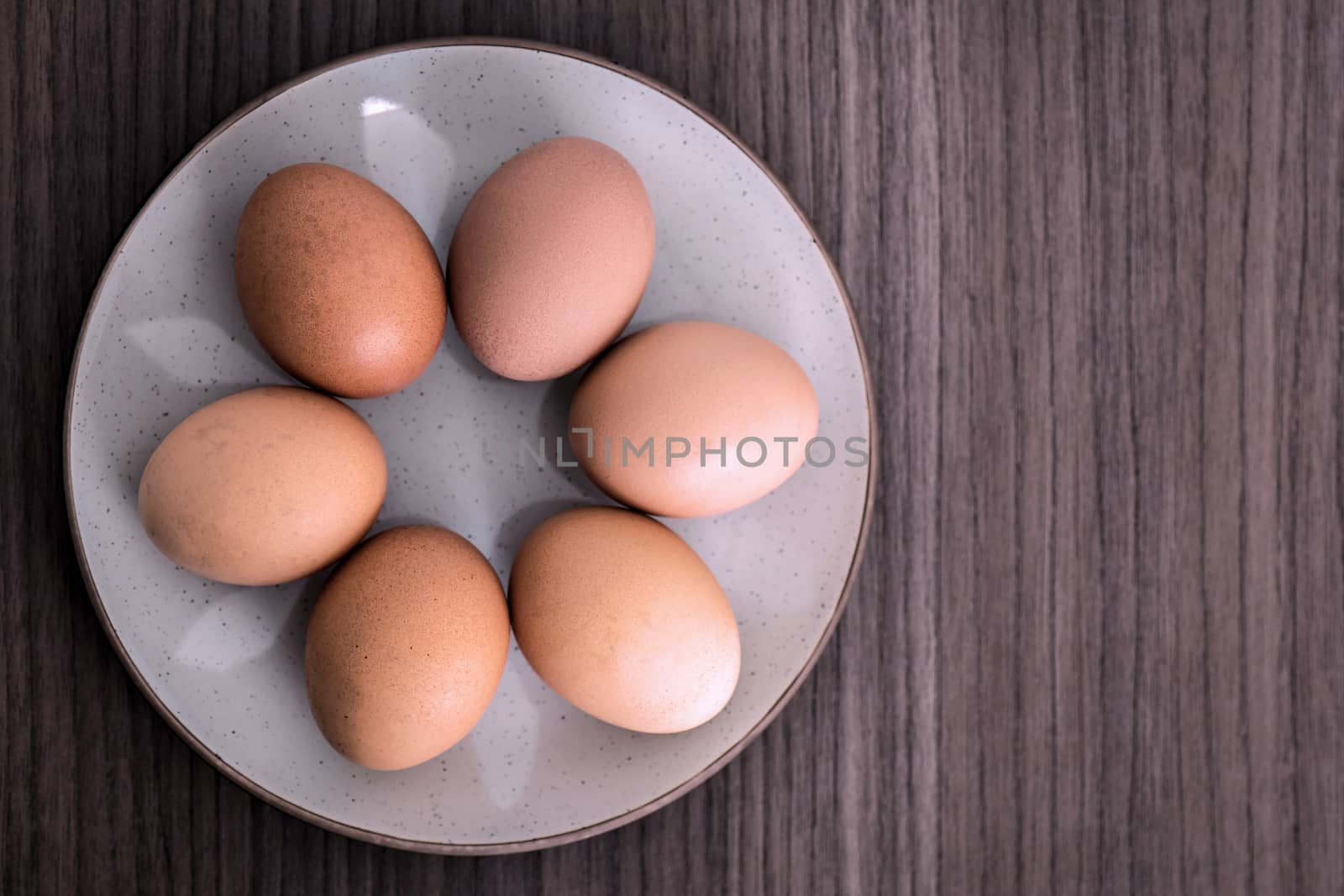 Six raw eggs arranged in a round dish 