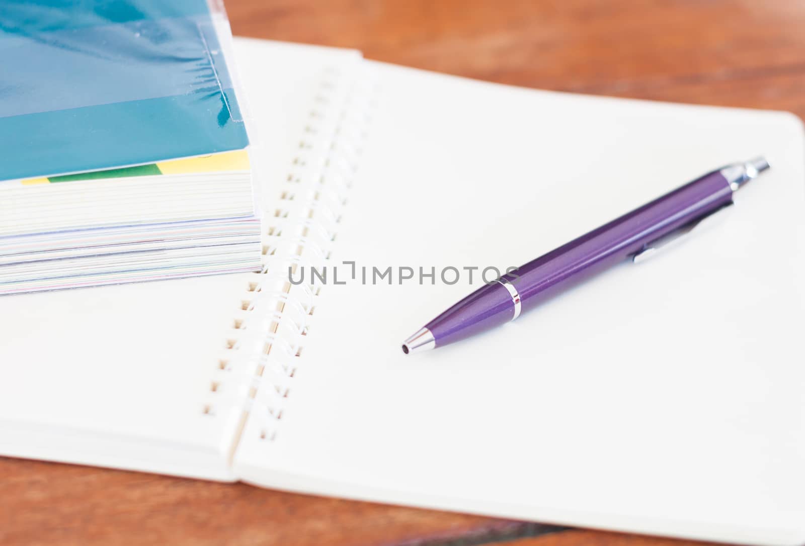 Blank notebook with pen on wooden table, stock photo