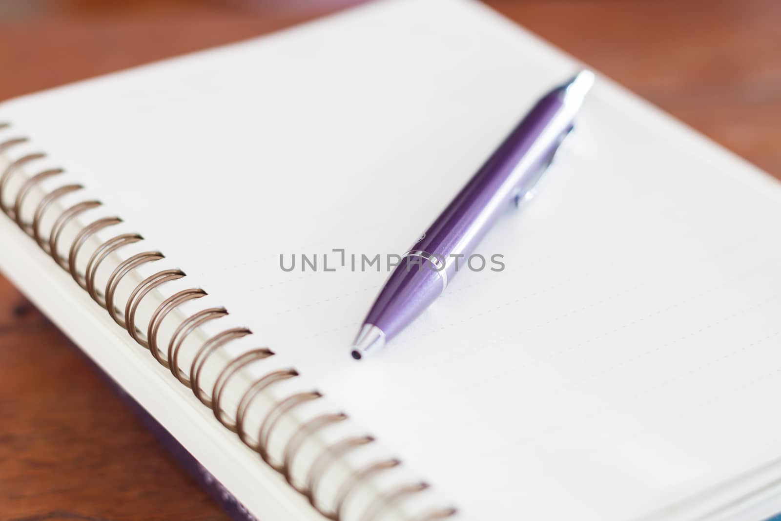 Blank notebook with pen on wooden table, stock photo