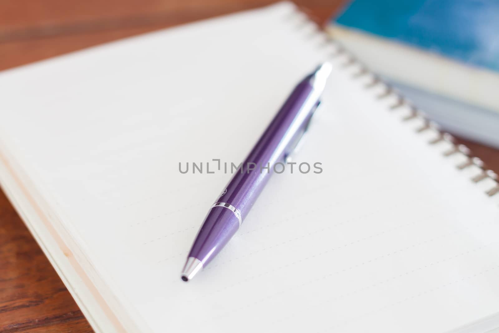 Blank notebook with pen on wooden table, stock photo