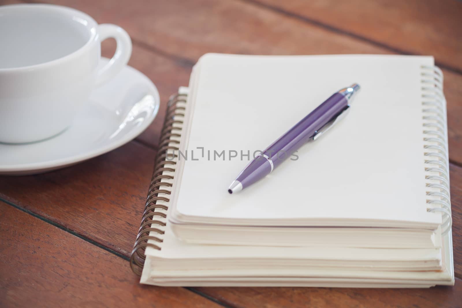 Blank notebook with pen on wooden table, stock photo