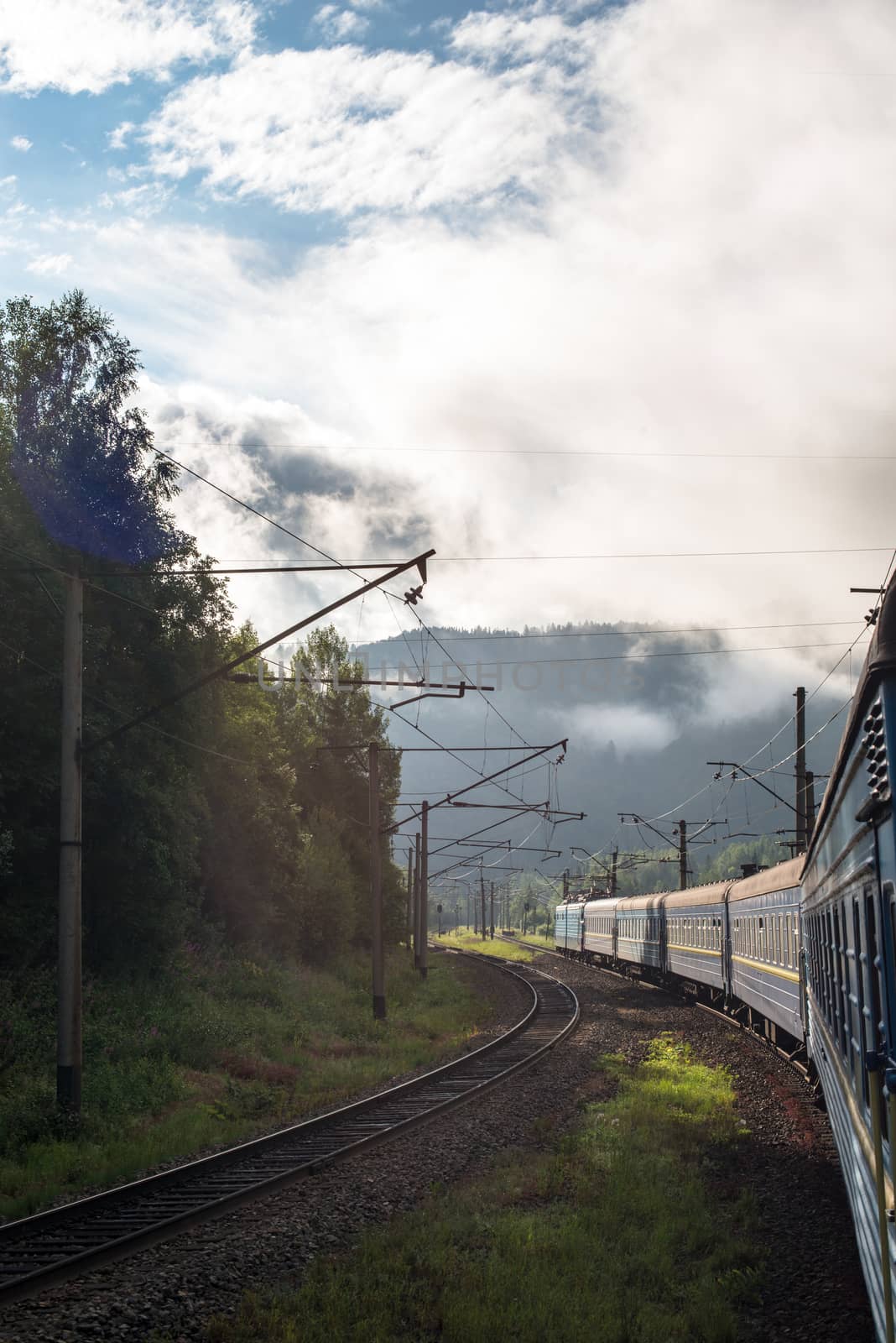 Passenger train going in the Carpathian Mountains by rootstocks
