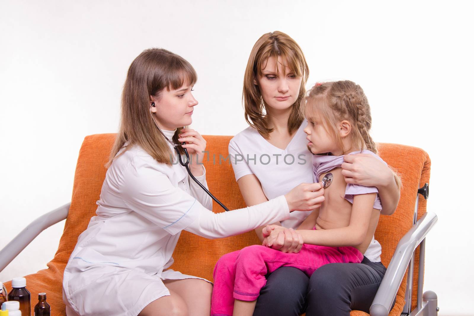 Doctor pediatrician examines a sick child at home in the presence of my mother