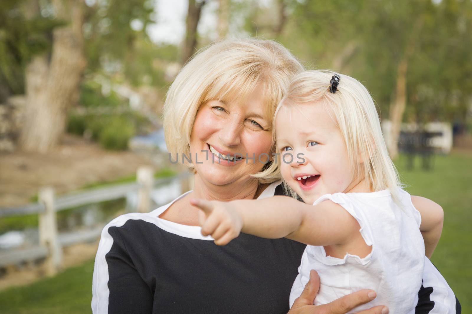 Affectionate Grandmother and Granddaughter Playing Outside At The Park.