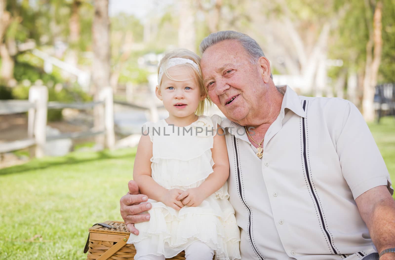 Loving Grandfather and Granddaughter Hugging Outside At The Park.