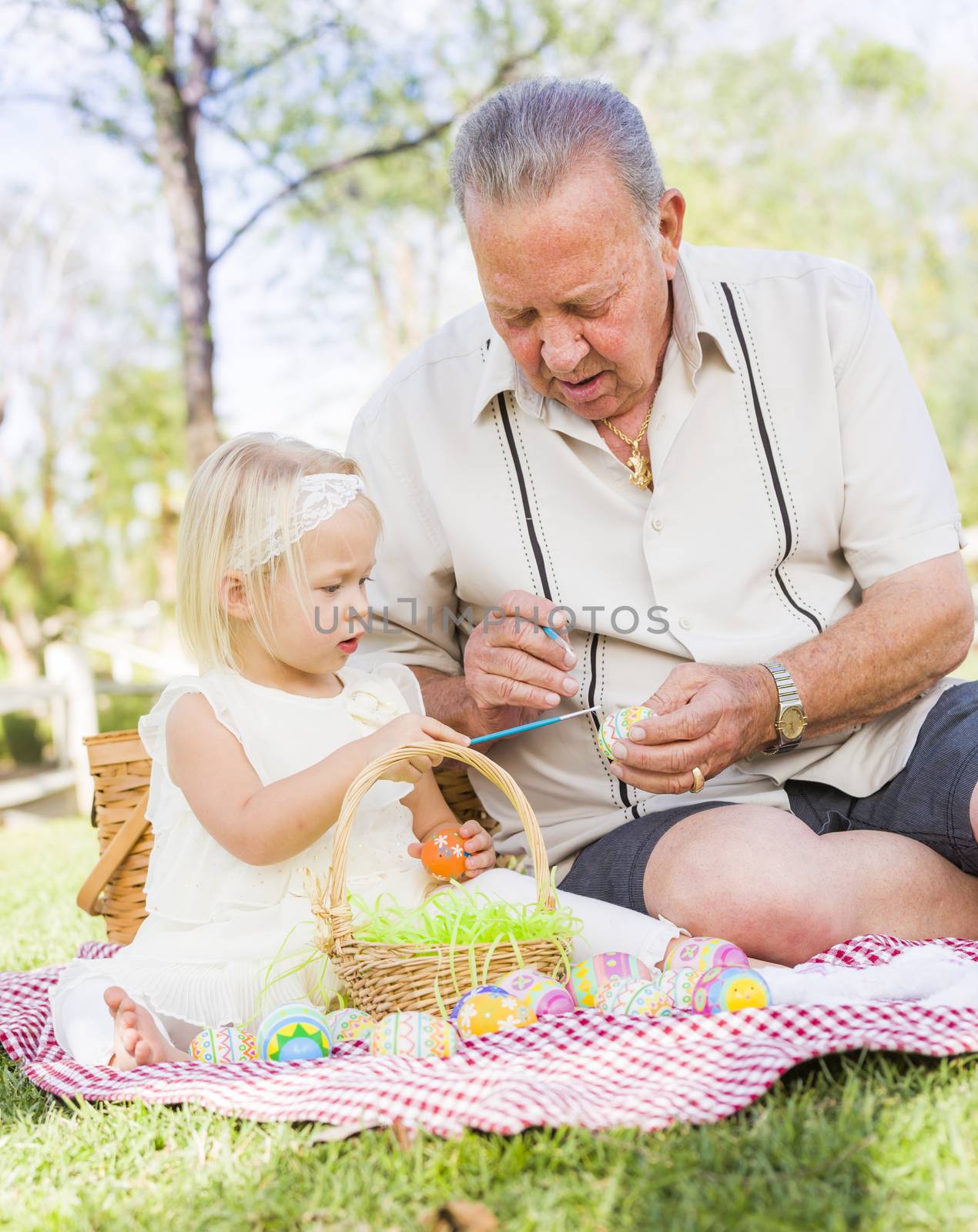 Grandfather and Granddaughter Coloring Easter Eggs on Blanket At by Feverpitched