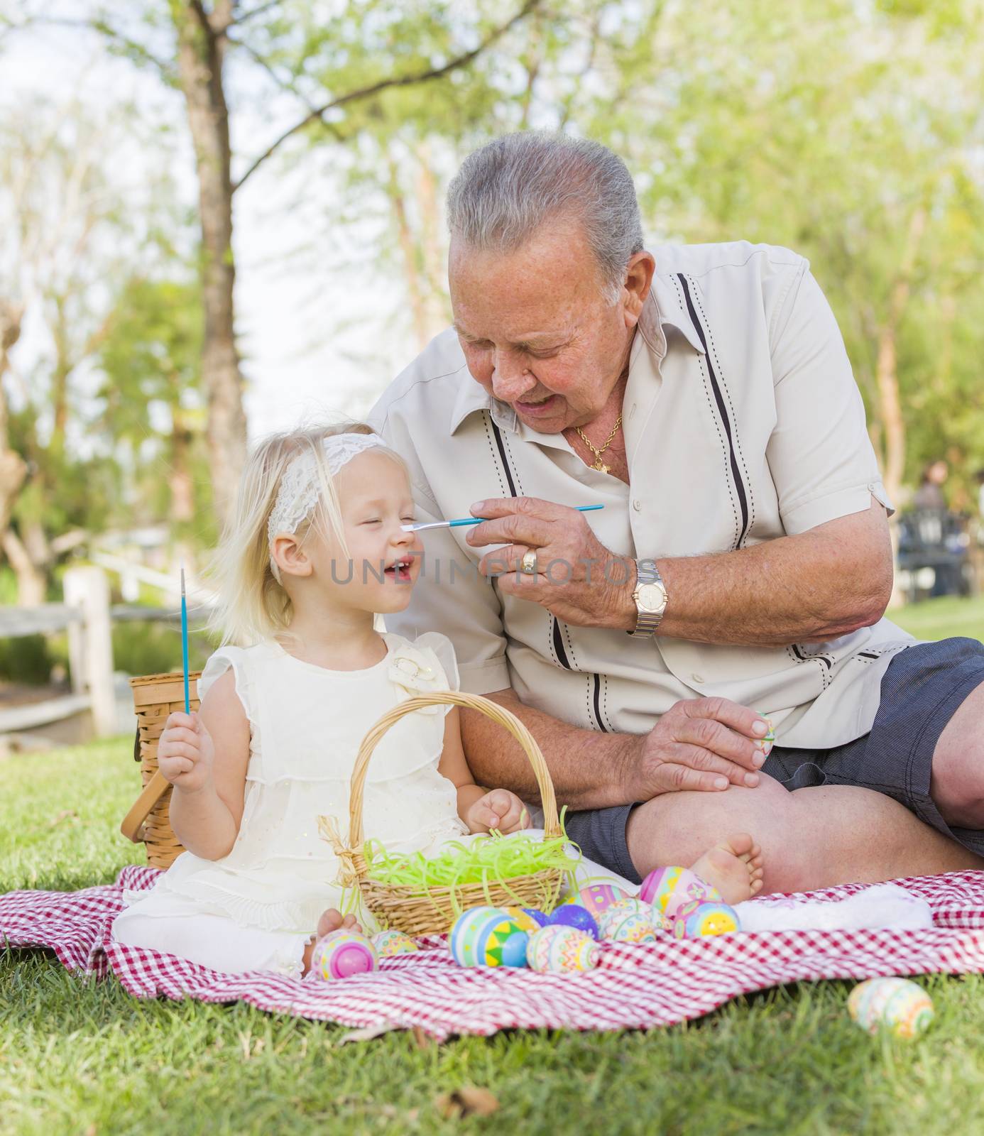 Grandfather and Granddaughter Coloring Easter Eggs on Blanket At by Feverpitched