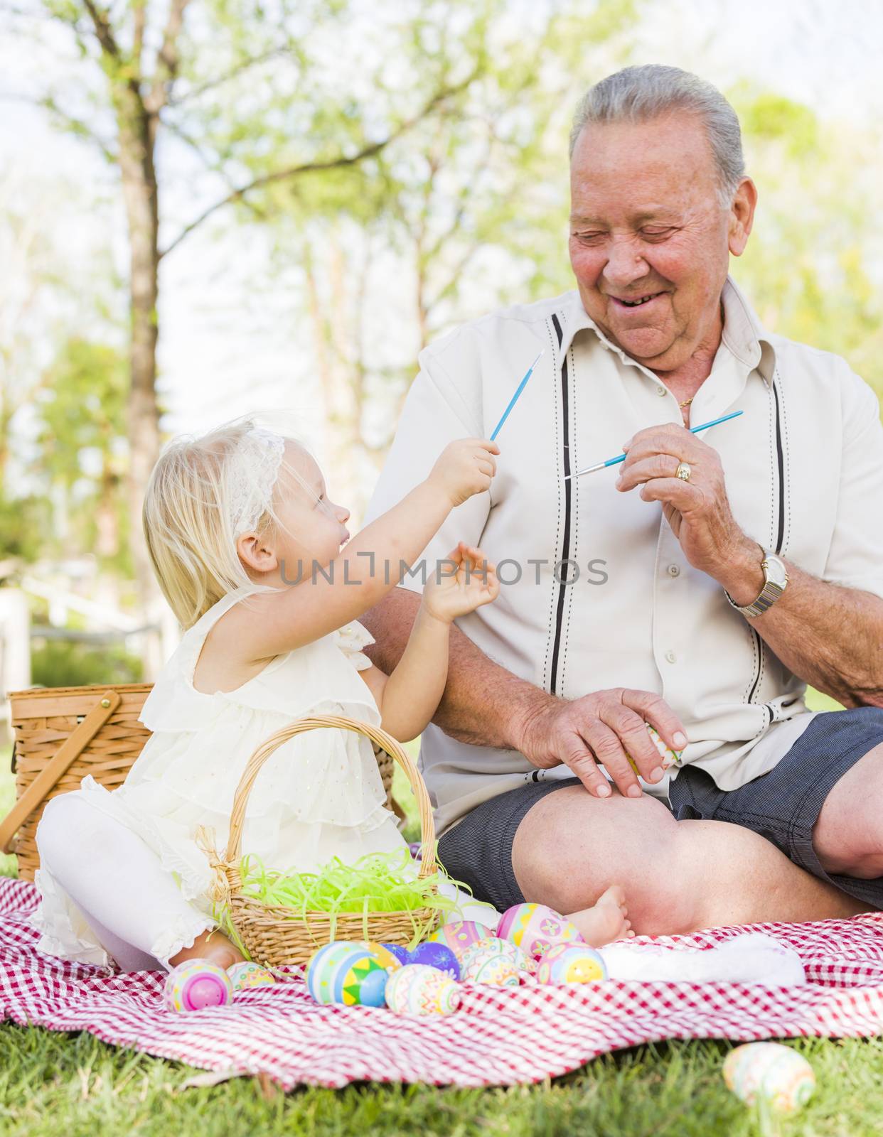 Grandfather and Granddaughter Coloring Easter Eggs on Blanket At by Feverpitched