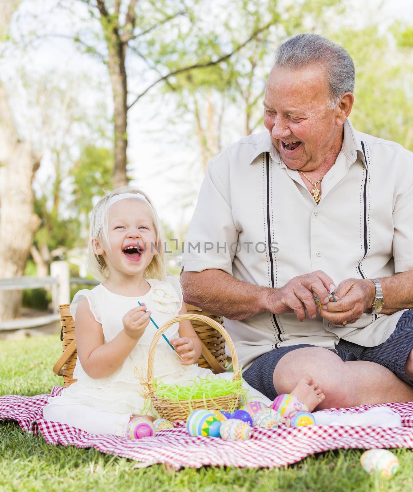 Grandfather and Granddaughter Coloring Easter Eggs on Blanket At by Feverpitched