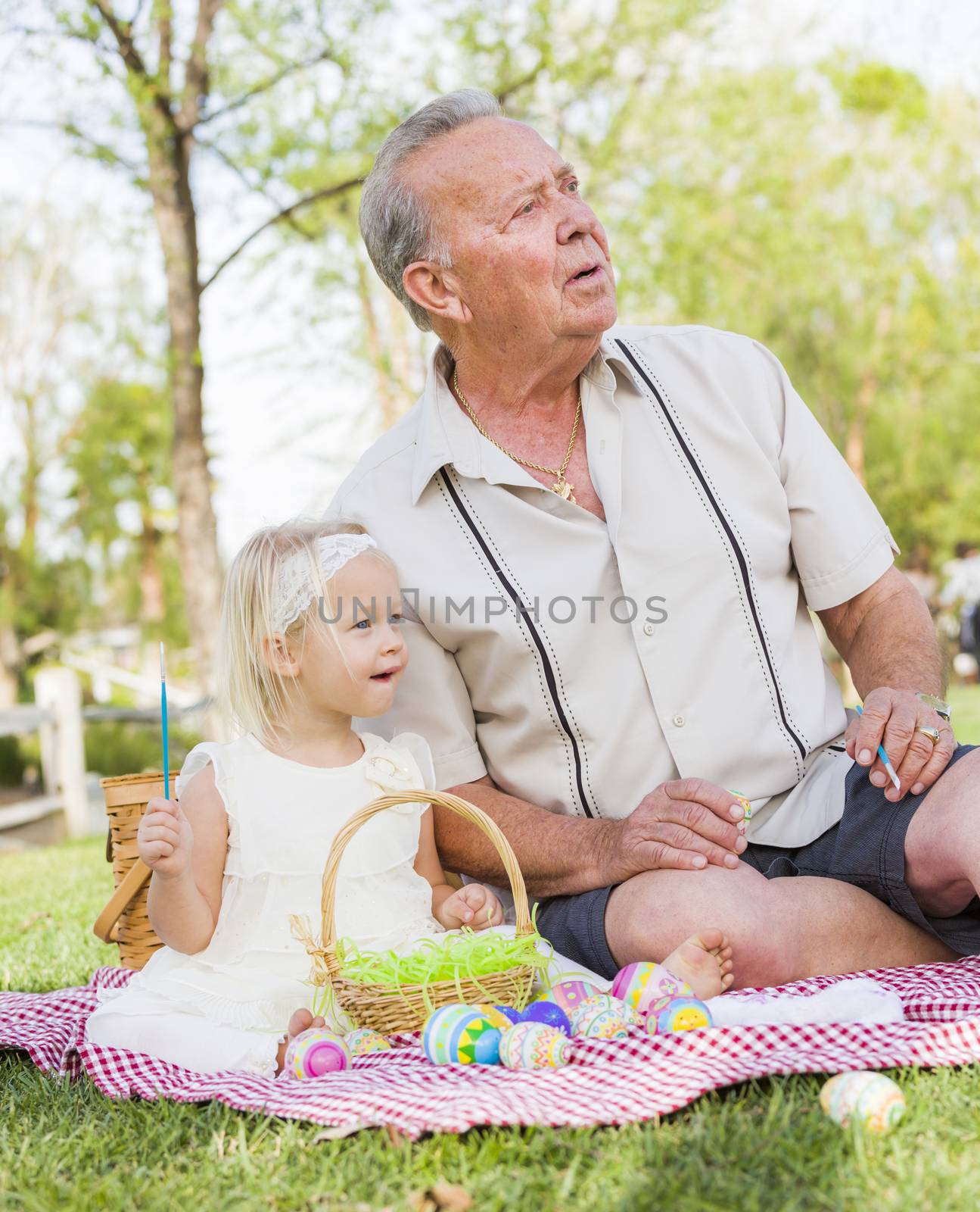 Grandfather and Granddaughter Coloring Easter Eggs on Blanket At by Feverpitched