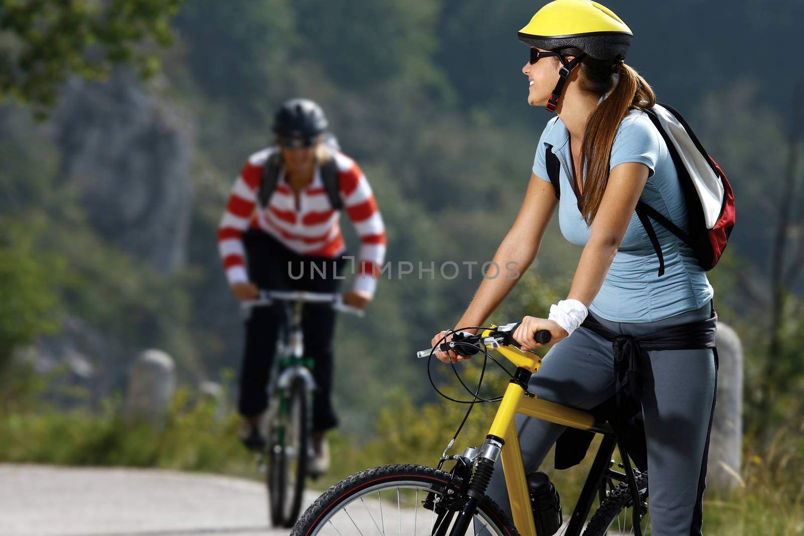 Beautiful happy women biking on road of countryside at summer