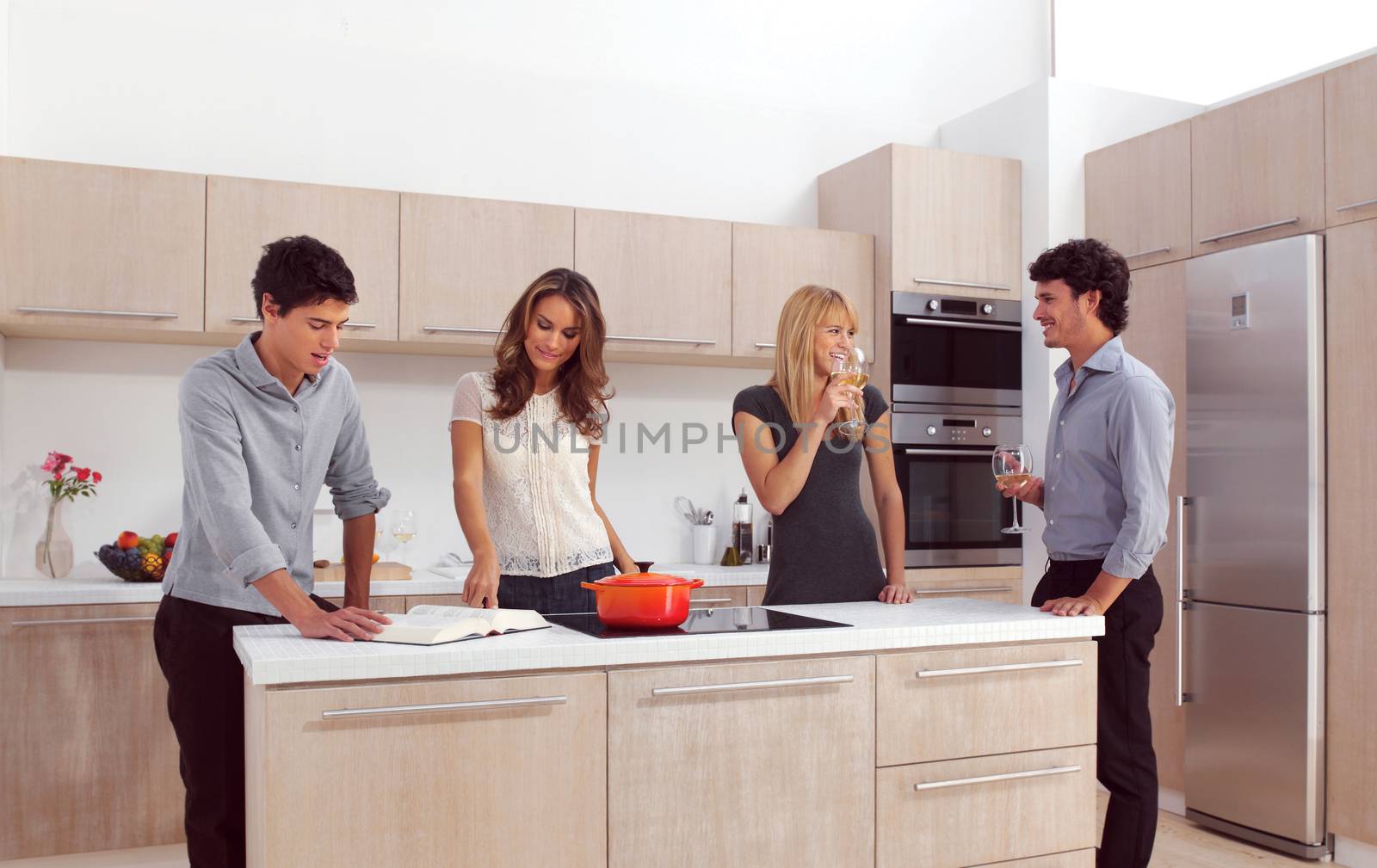 Group Of Young Friends Preparing Breakfast In Modern Kitchen