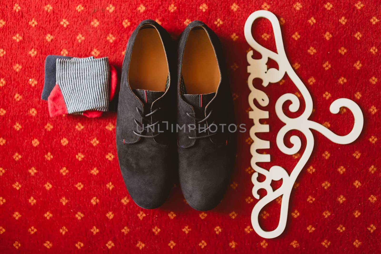 The groom's shoes and socks on the carpet