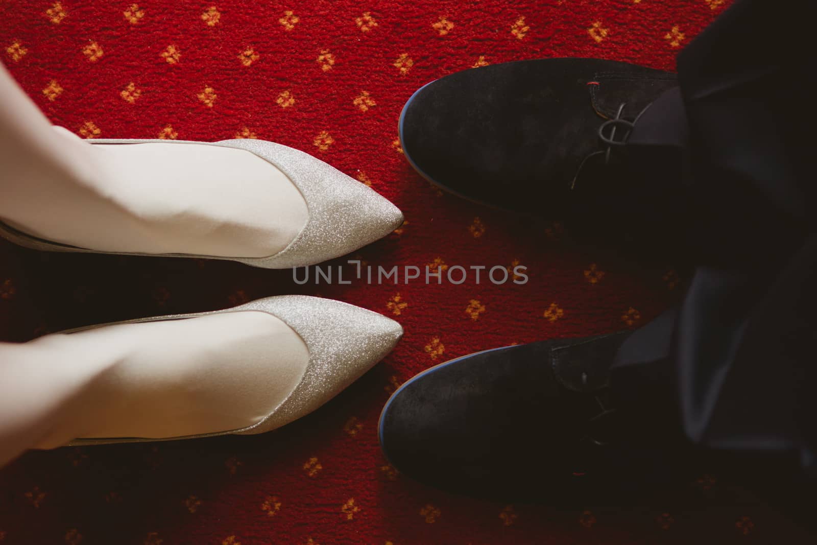 Bride's and groom's shoes on carpet. wedding background