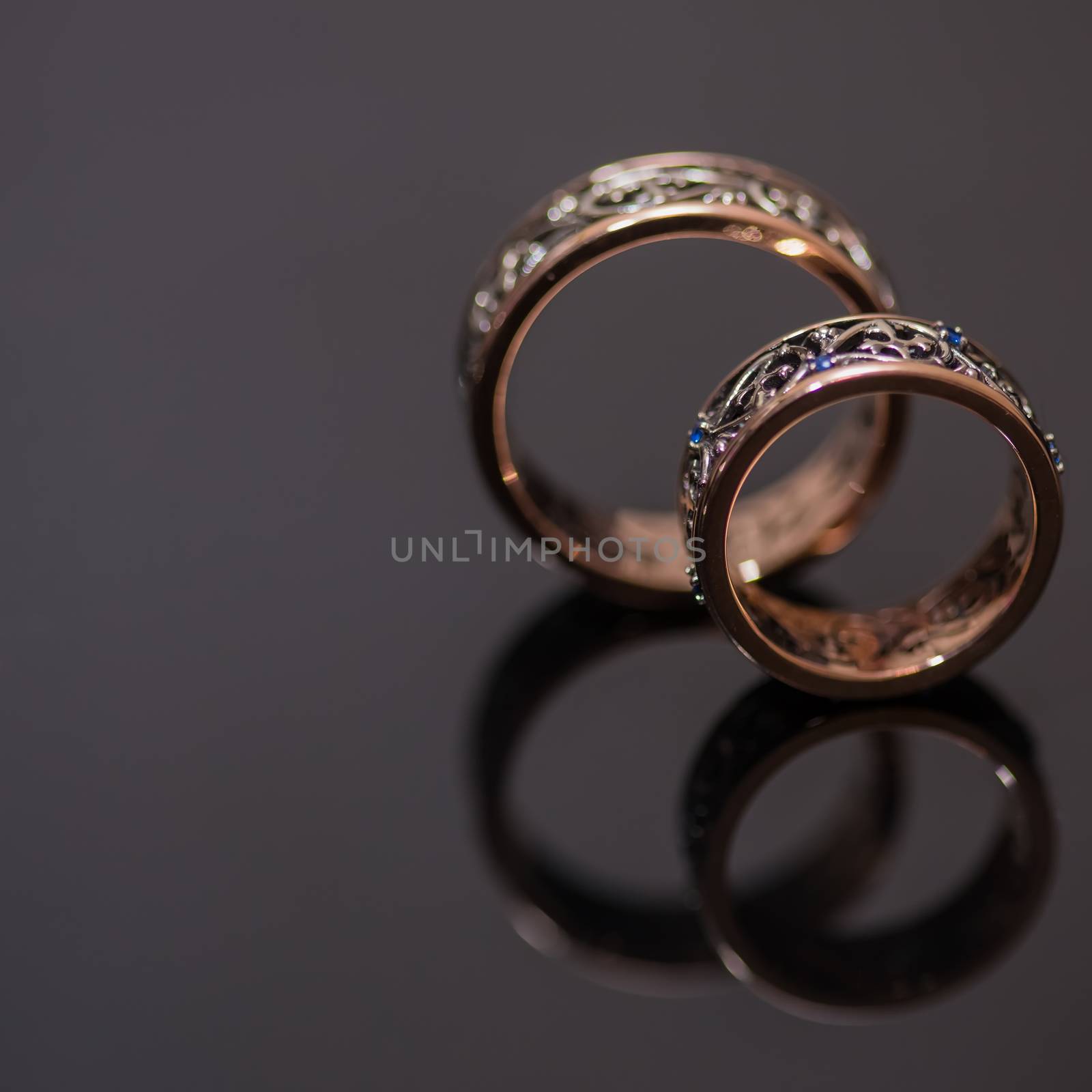 Two wedding rings in infinity sign on black background. Love concept.