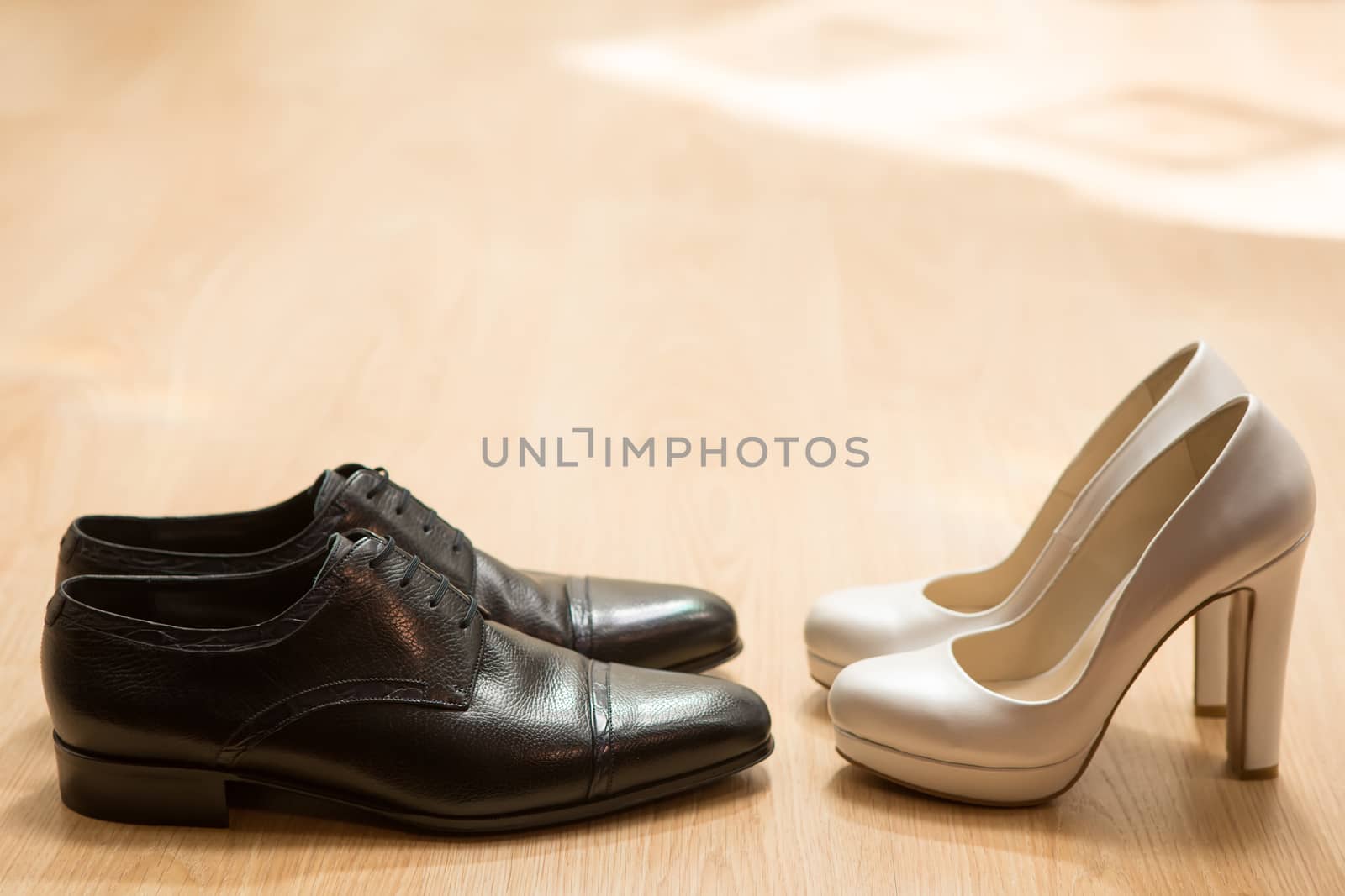 Bride&#39;s and groom&#39;s shoes on parquet. wedding background