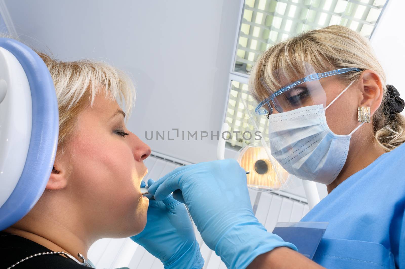 dentist at work with patient, dental exam, polishing and finishing