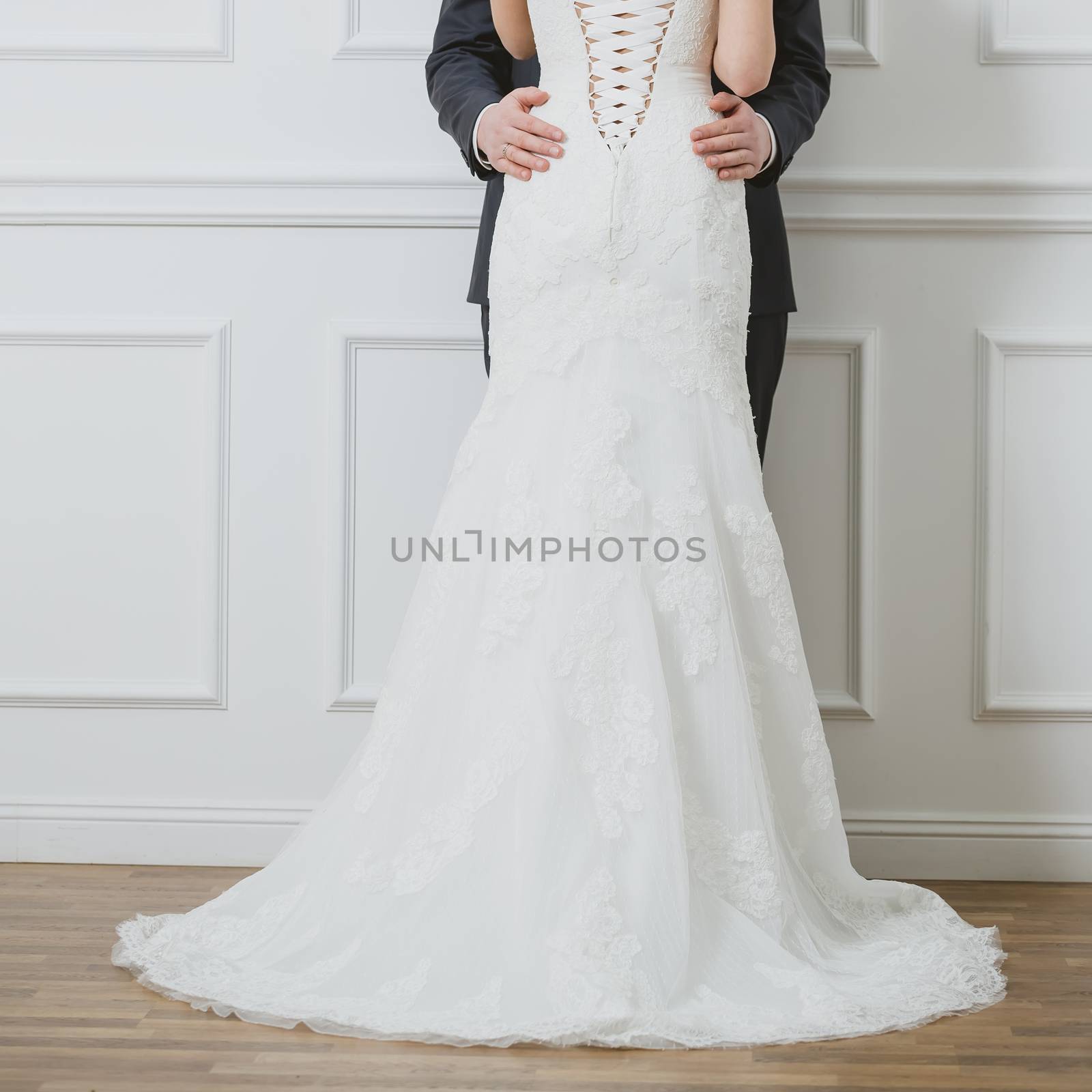 Elegant bride and groom posing together in studio on a wedding day