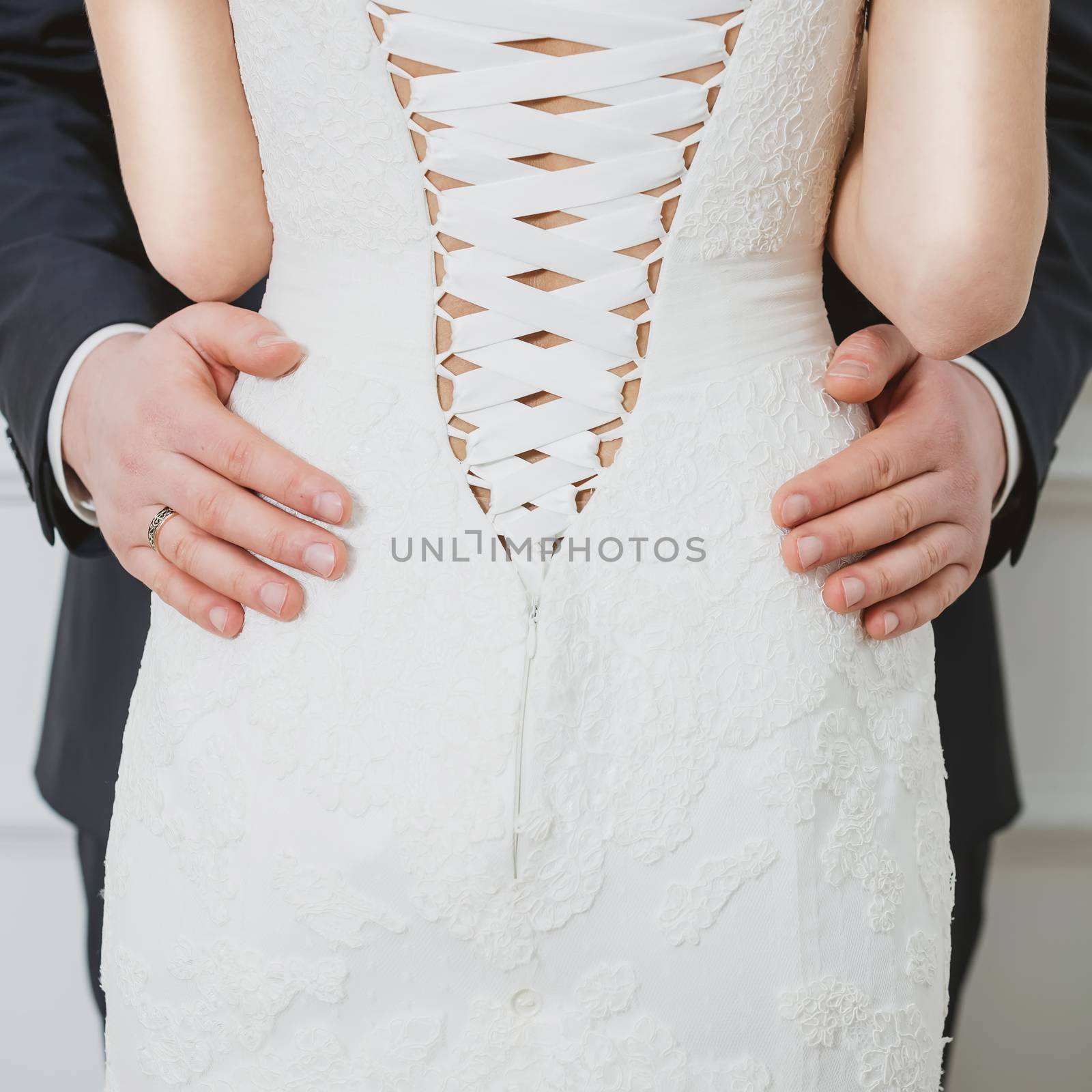 Elegant bride and groom posing together in studio on a wedding day