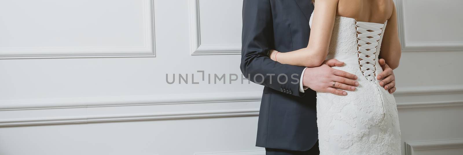 Elegant bride and groom posing together in studio on a wedding day