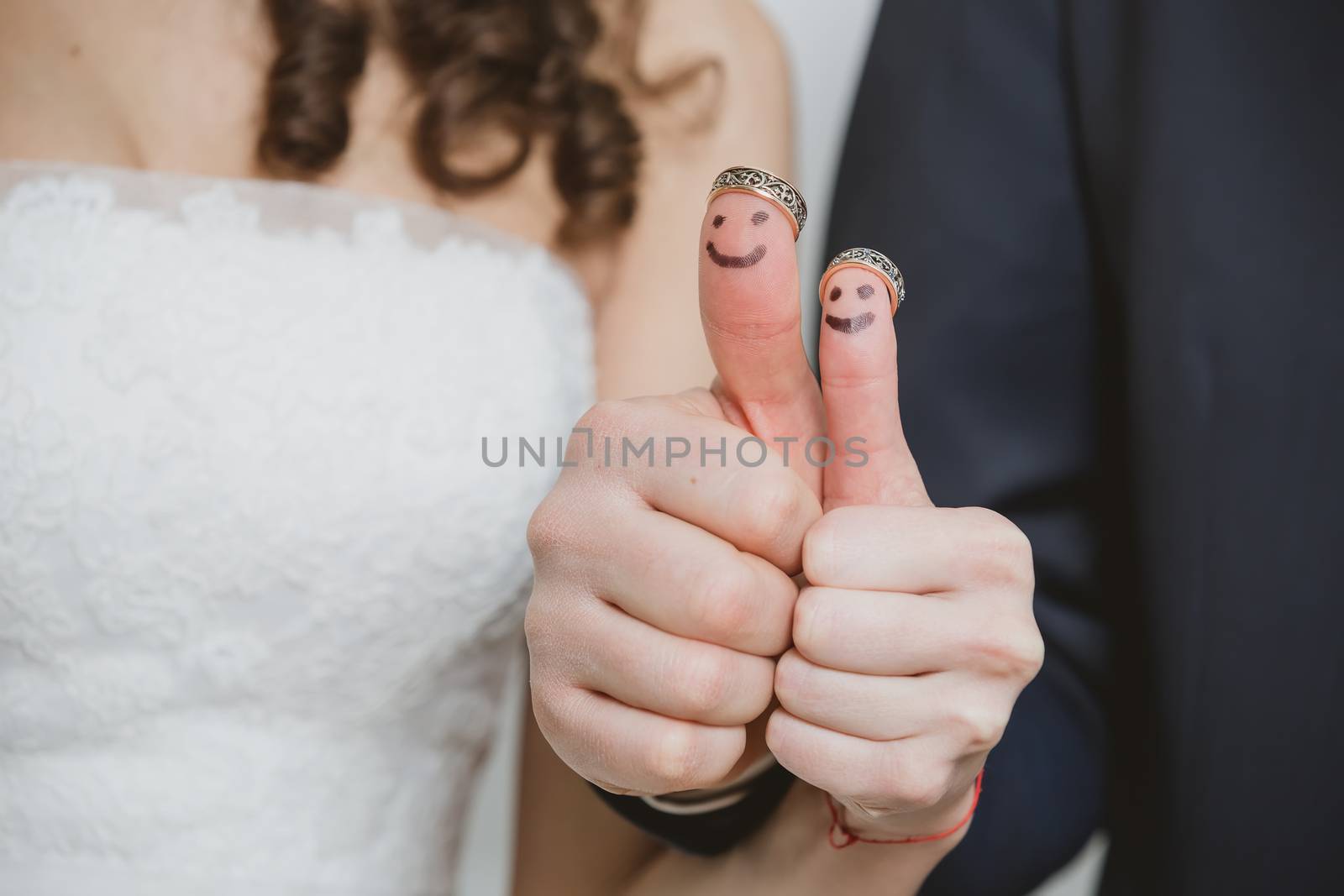 wedding rings on their fingers painted with the bride and groom, funny little people by sarymsakov