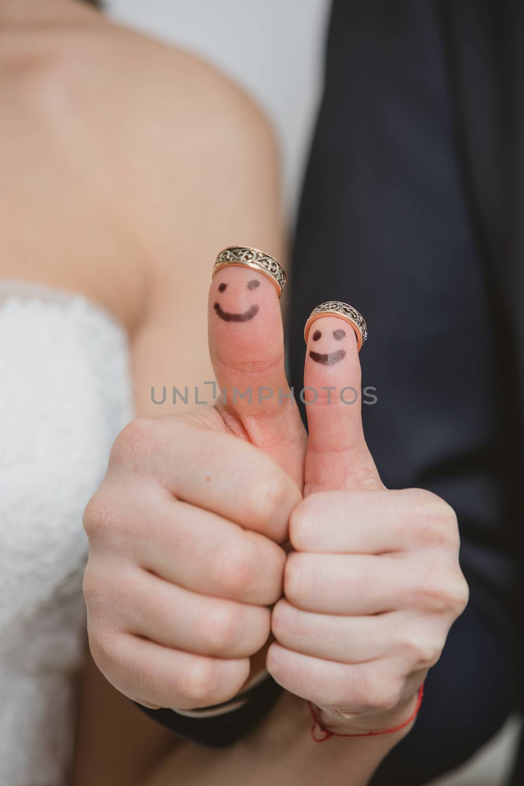 wedding rings on their fingers painted with the bride and groom, funny little people. conceptual idea