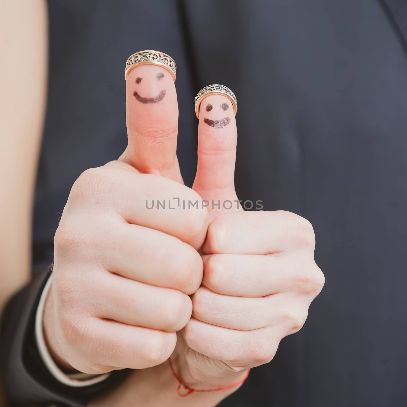 wedding rings on their fingers painted with the bride and groom, funny little people. conceptual idea