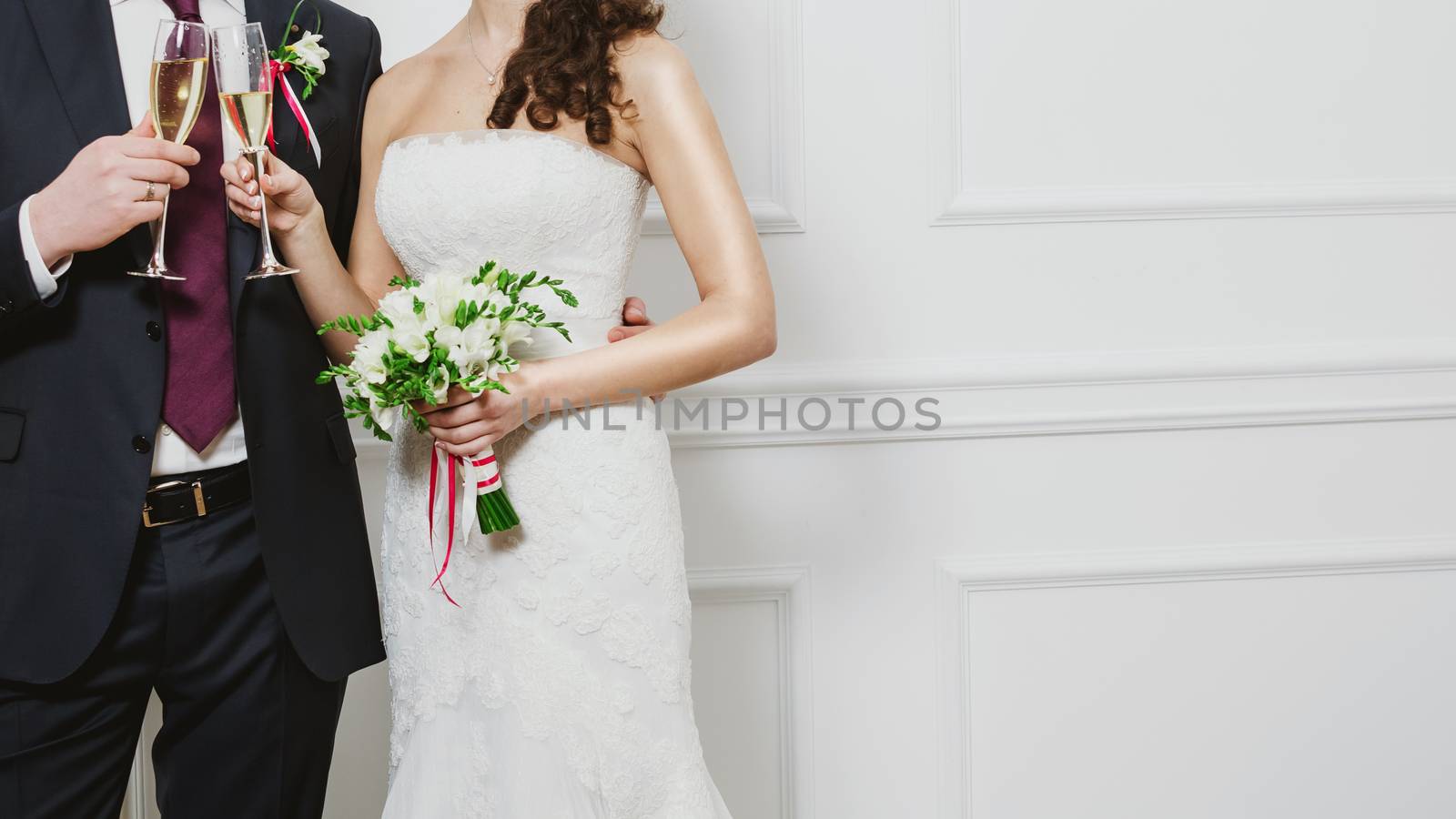 Elegant bride and groom posing together in studio on a wedding day