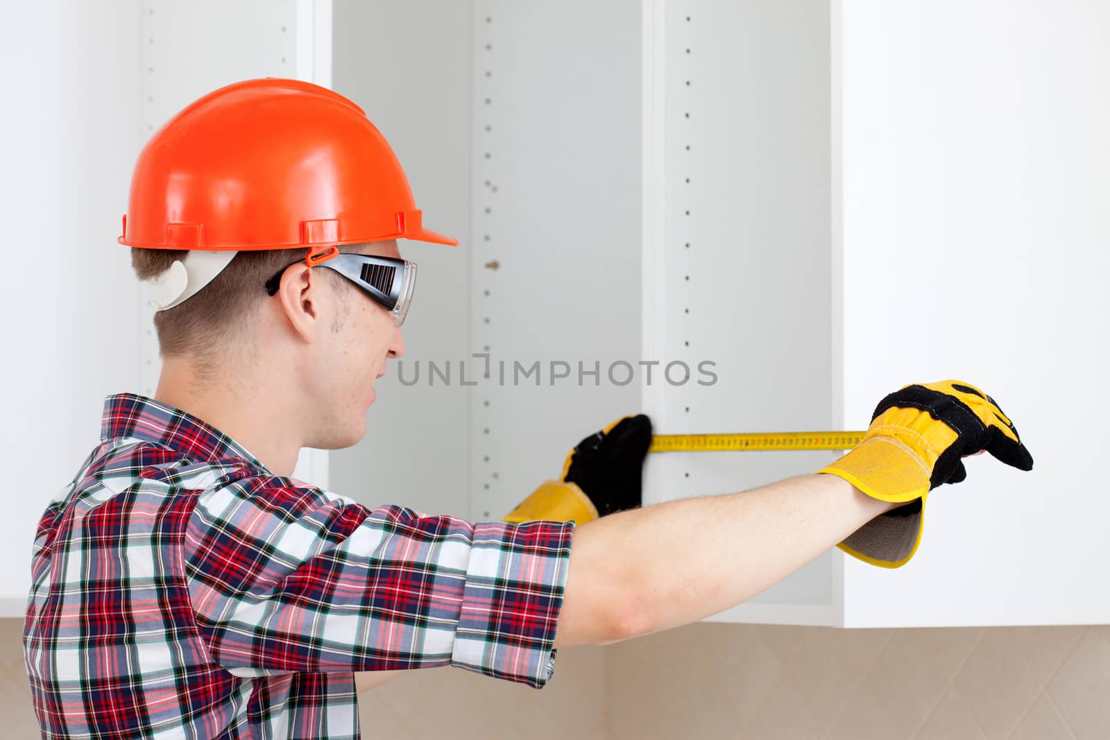 builder measures the length of the tape measure