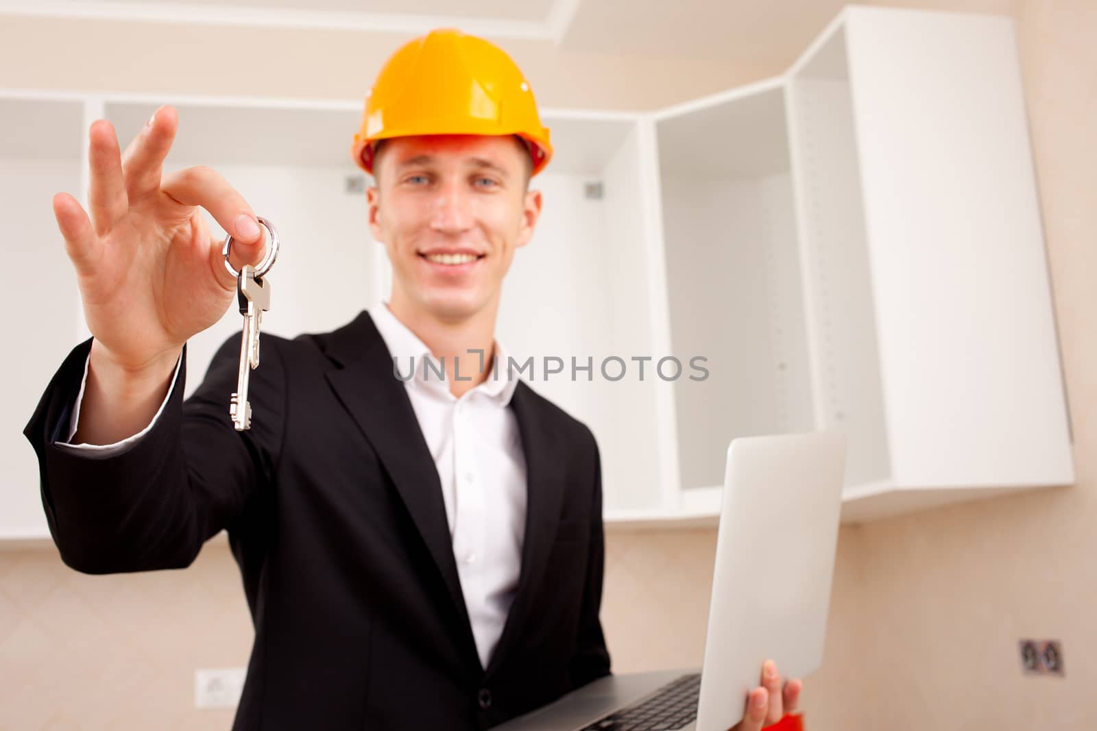 civil engineer with a laptop gives the keys to the apartment