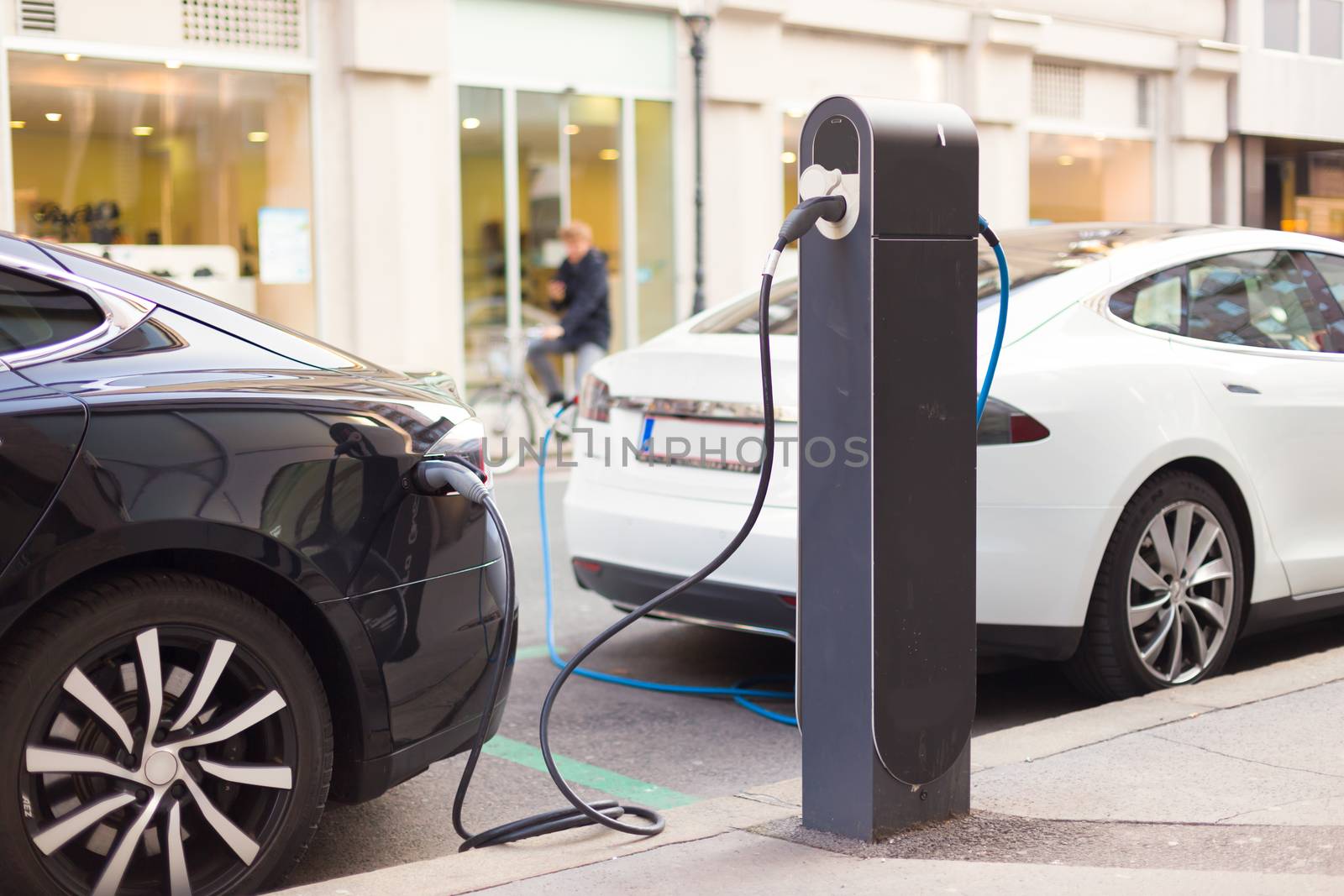 Power supply for electric car charging.  Electric car charging station. Close up of the power supply plugged into an electric car being charged.