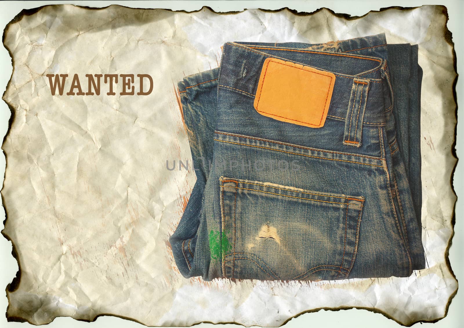 aged jeans on old paper with the inscription Wanted , vintage still life