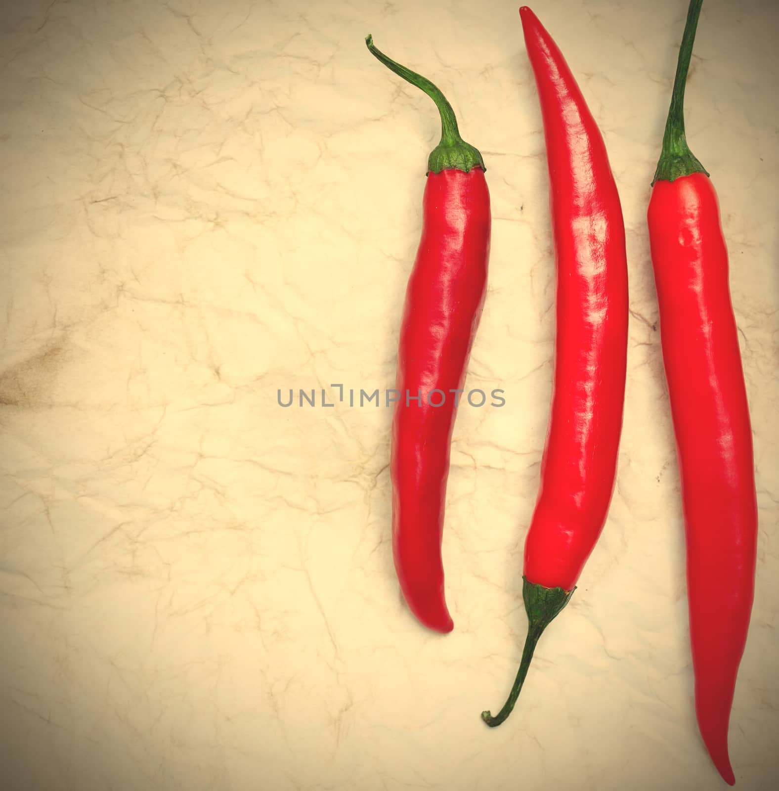 three red hot chili peppers on the paper background. instagram image style